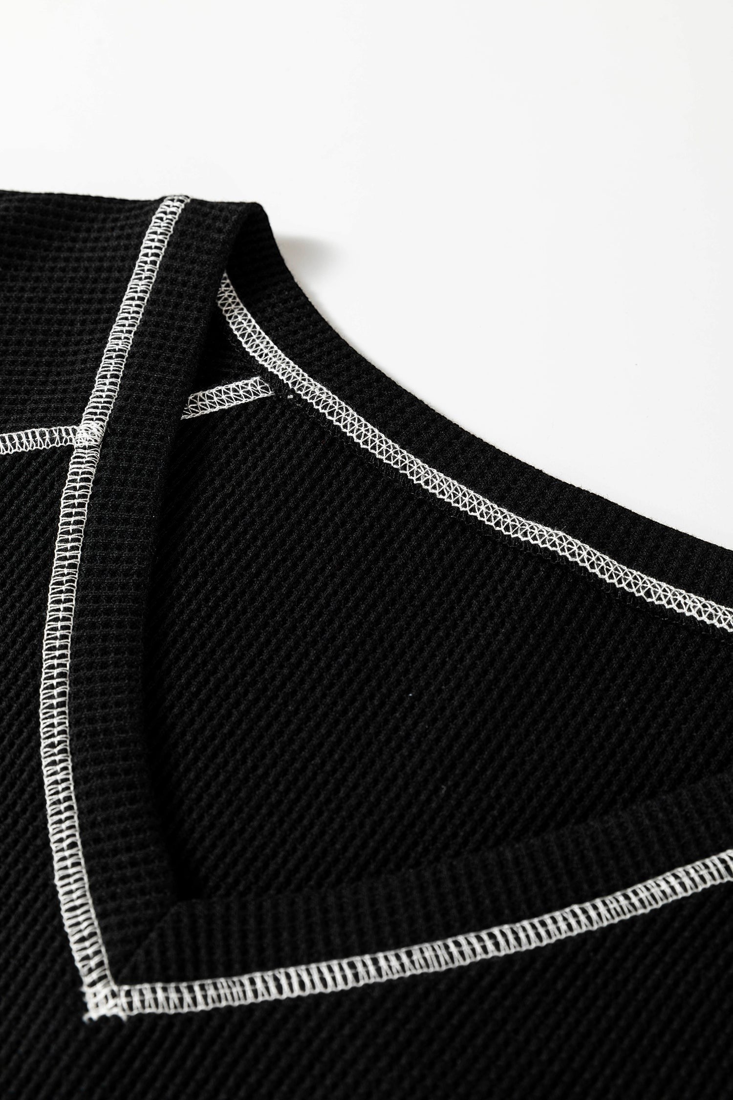 Doodlations Coffee Bar & Boutique black waffle knit V-neck top featuring white contrast stitching detail.