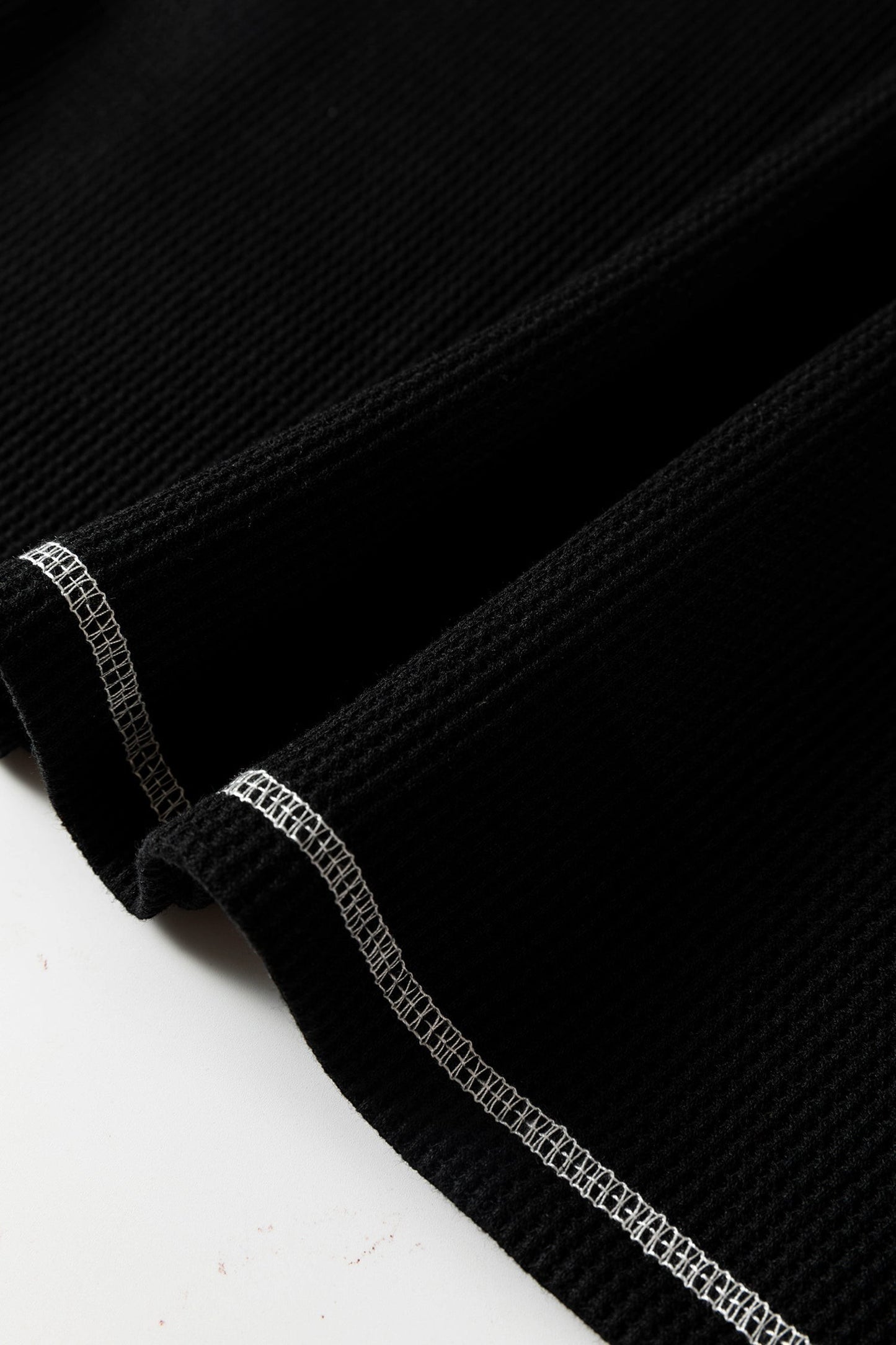 Doodlations Coffee Bar & Boutique black waffle knit top featuring white contrast stitching on the seams.