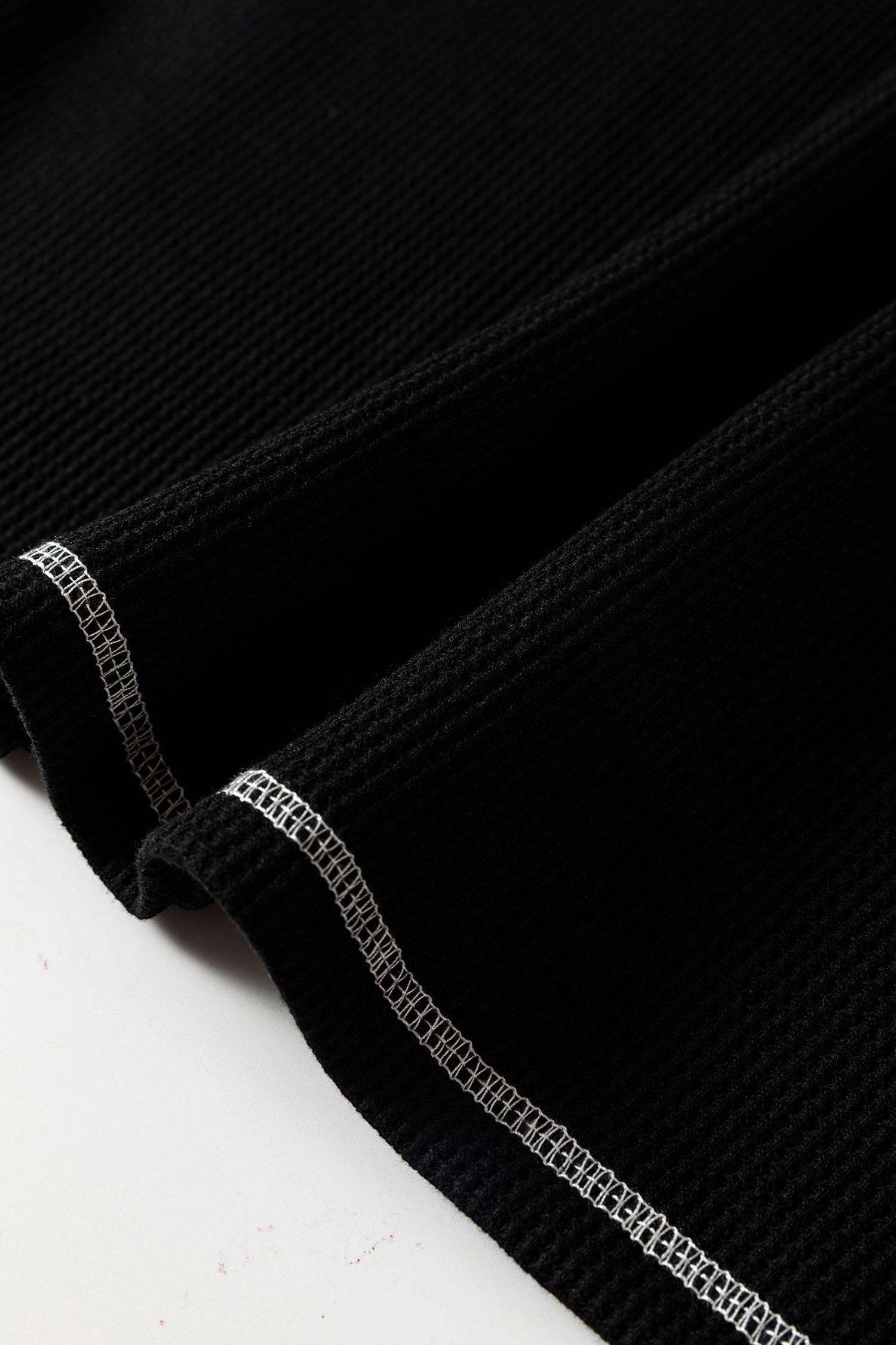 Doodlations Coffee Bar & Boutique black waffle knit top featuring white contrast stitching on the seams.