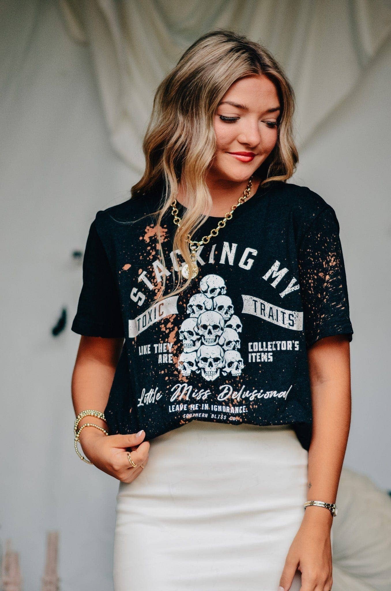 Doodlations Coffee Bar & Boutique black graphic tee with skull print and bleach splatter worn by a woman