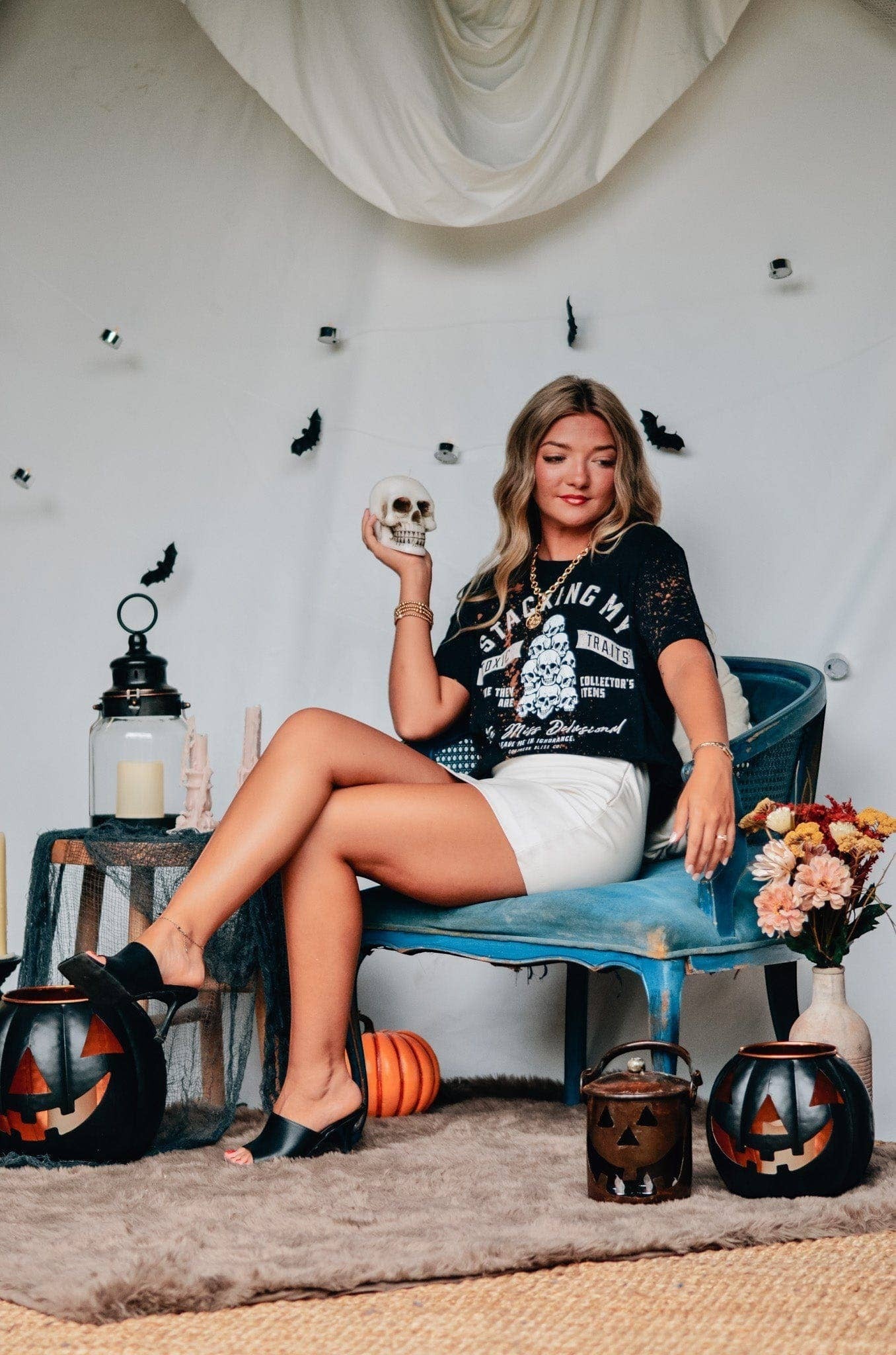 Doodlations Coffee Bar & Boutique black bleached graphic tee with skull design worn by a woman in a Halloween setting