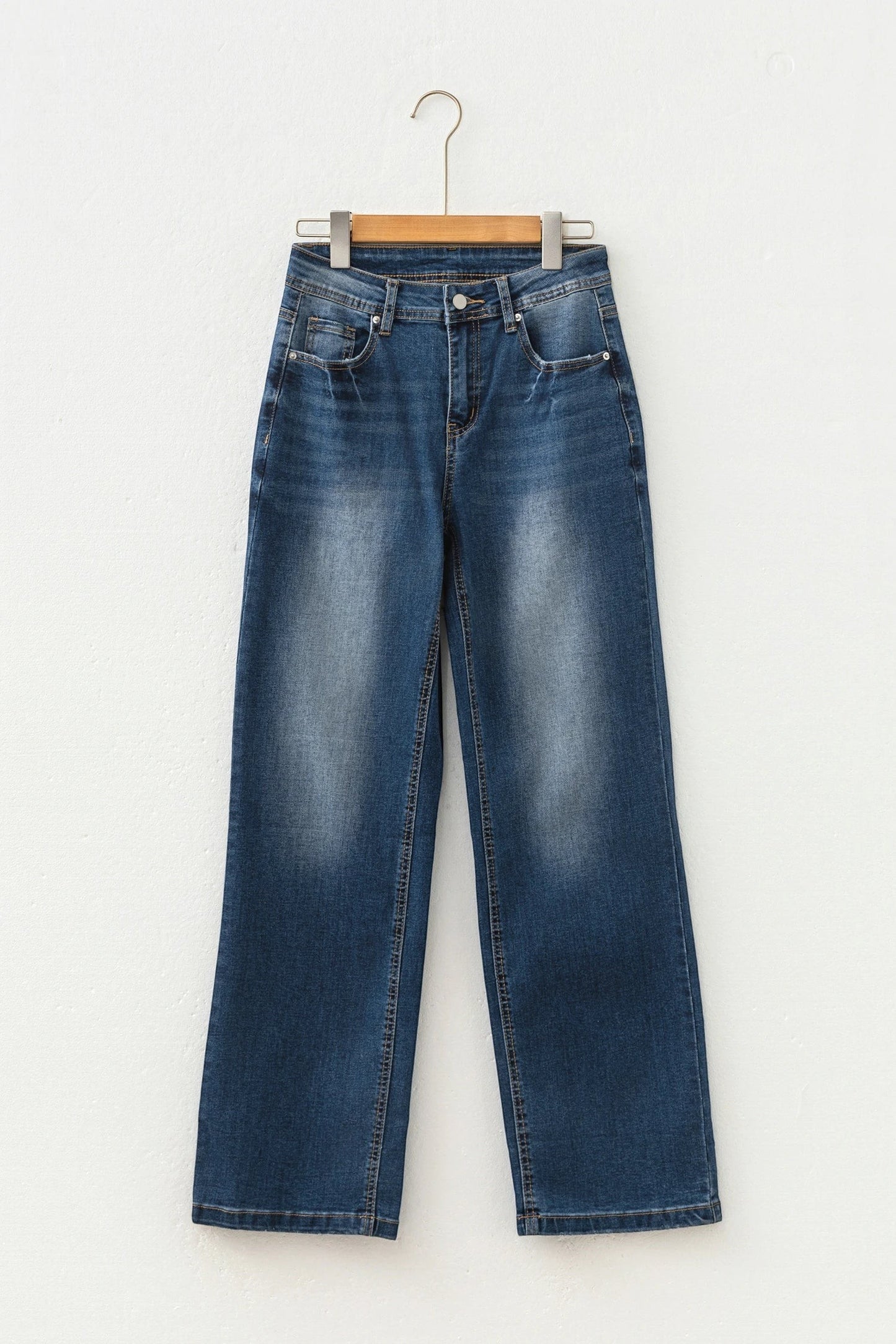 Doodlations Coffee Bar & Boutique Ashleigh blue acid-washed straight leg denim jeans on a hanger