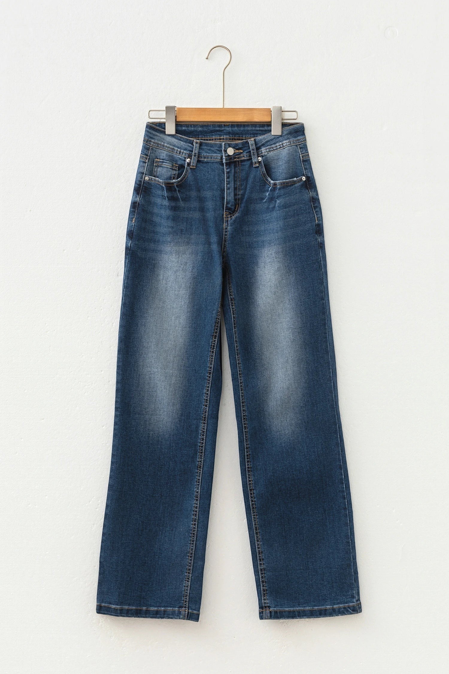 Doodlations Coffee Bar & Boutique Ashleigh blue acid-washed straight leg denim jeans on a hanger