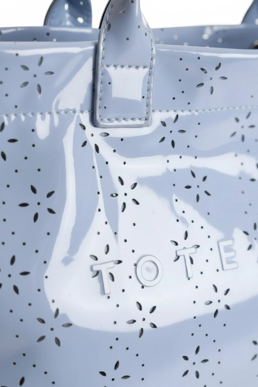 Doodlations Coffee Bar & Boutique baby blue glossy PVC tote bag with delicate floral eyelet pattern and metal hardware.