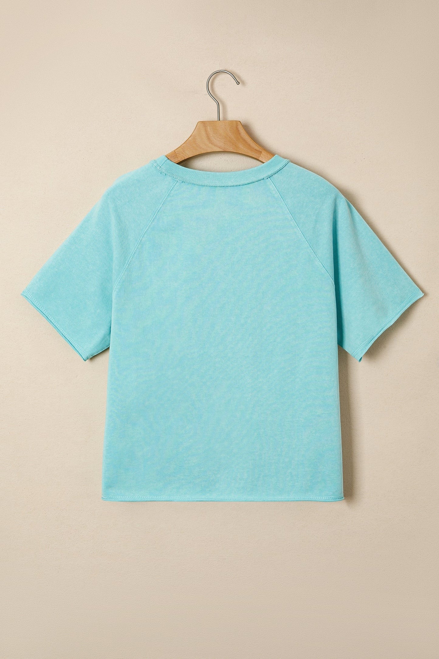 Doodlations Coffee Bar & Boutique light blue mineral wash cotton blend relaxed fit tee with raw edge hem and sleeves.