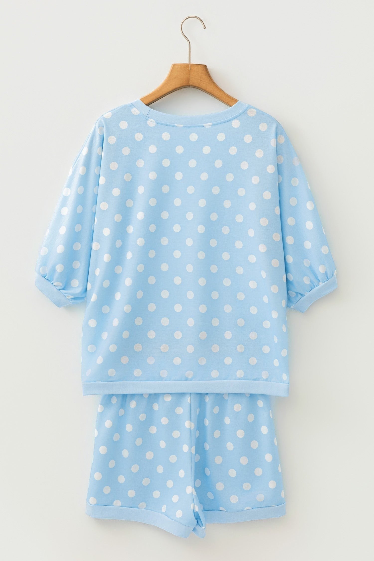 Doodlations Coffee Bar & Boutique light blue polka dot lounge set with a crew neck top and matching shorts on a hanger.