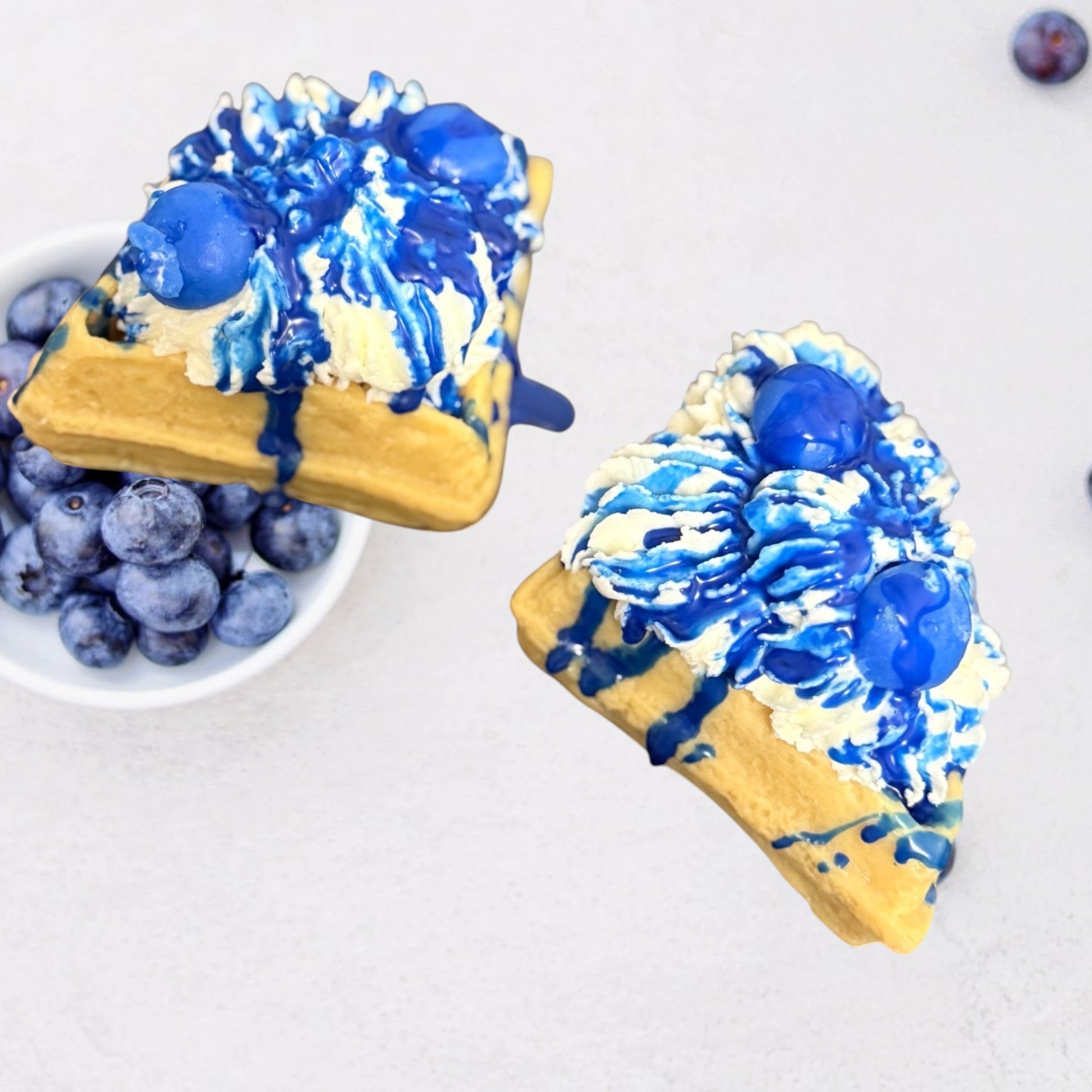 Doodlations Coffee Bar & Boutique Blueberry Waffle wax melts shaped like waffles with whipped cream and blue drizzle.