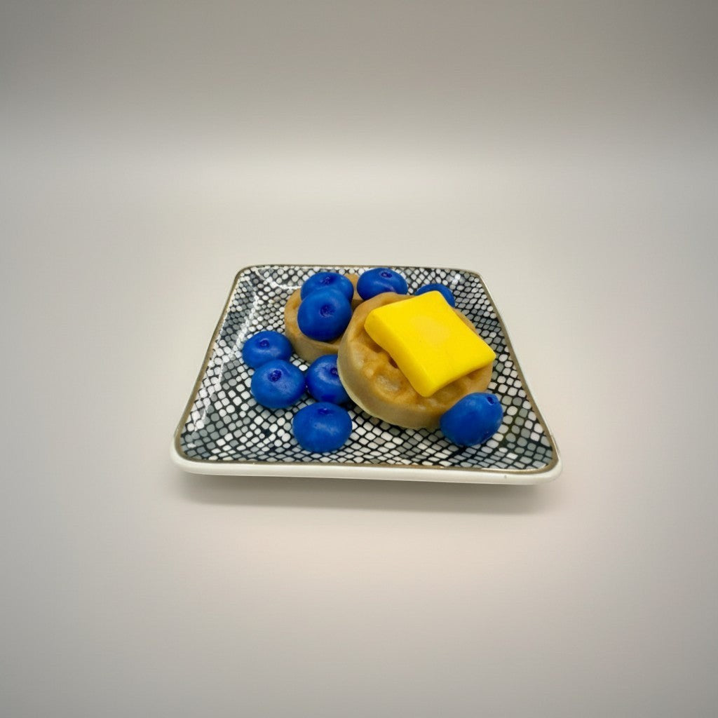 Doodlations Coffee Bar & Boutique Blueberry Waffle wax melts shaped like waffles with blueberries and butter.