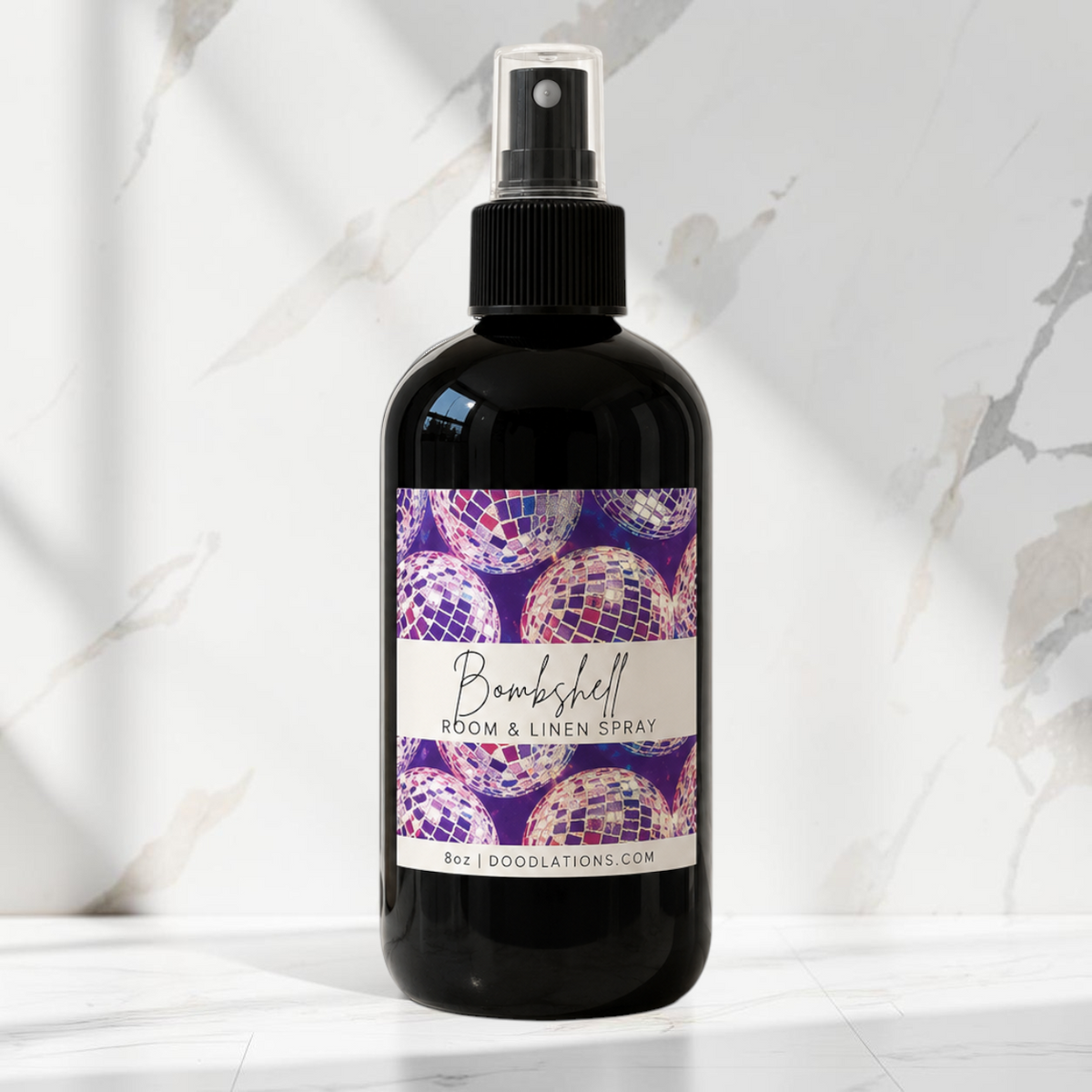Doodlations Coffee Bar & Boutique Bombshell room and linen spray in a black bottle with a disco ball label design.