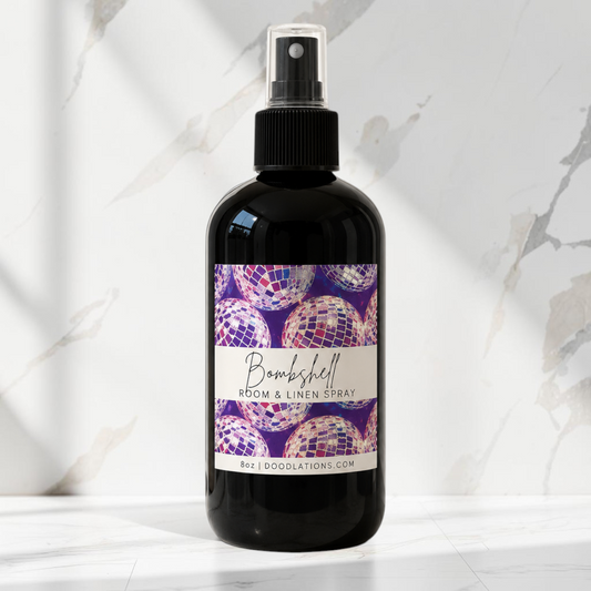 Doodlations Coffee Bar & Boutique Bombshell room and linen spray in a black bottle with a disco ball label design.