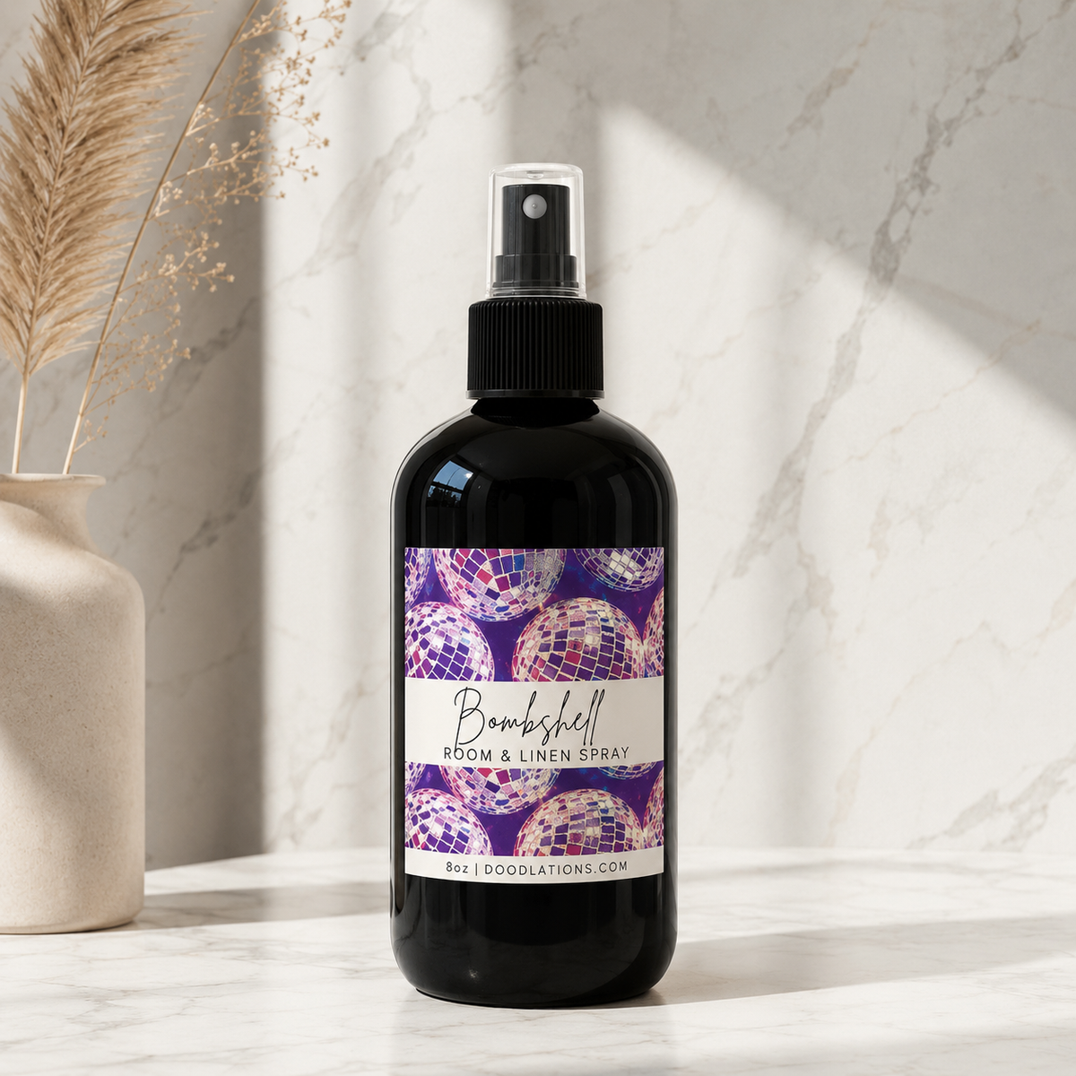 Doodlations Coffee Bar & Boutique Bombshell room and linen spray in a black bottle with a disco ball label design.