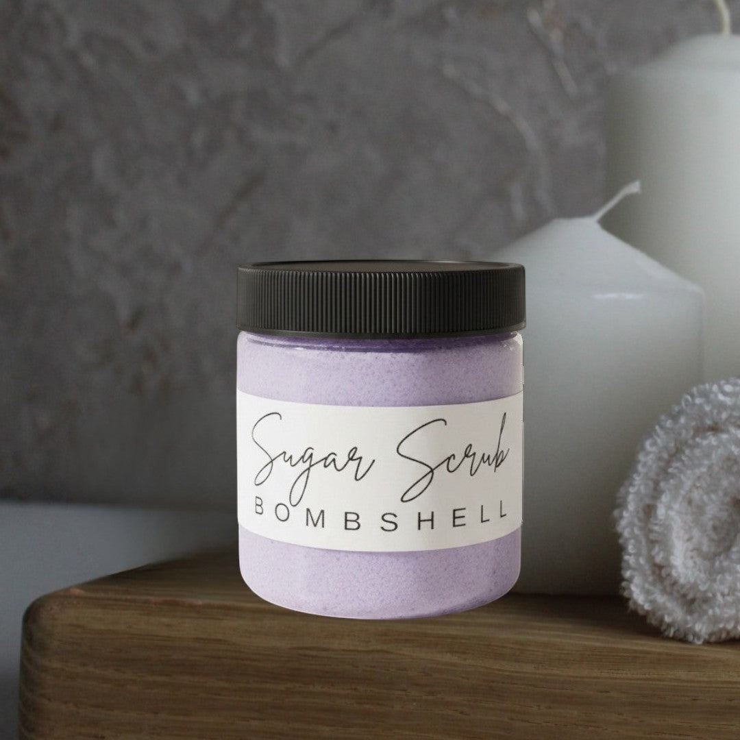 Doodlations Coffee Bar & Boutique Bombshell Sugar Scrub, a purple exfoliating scrub in a clear jar with a black lid.