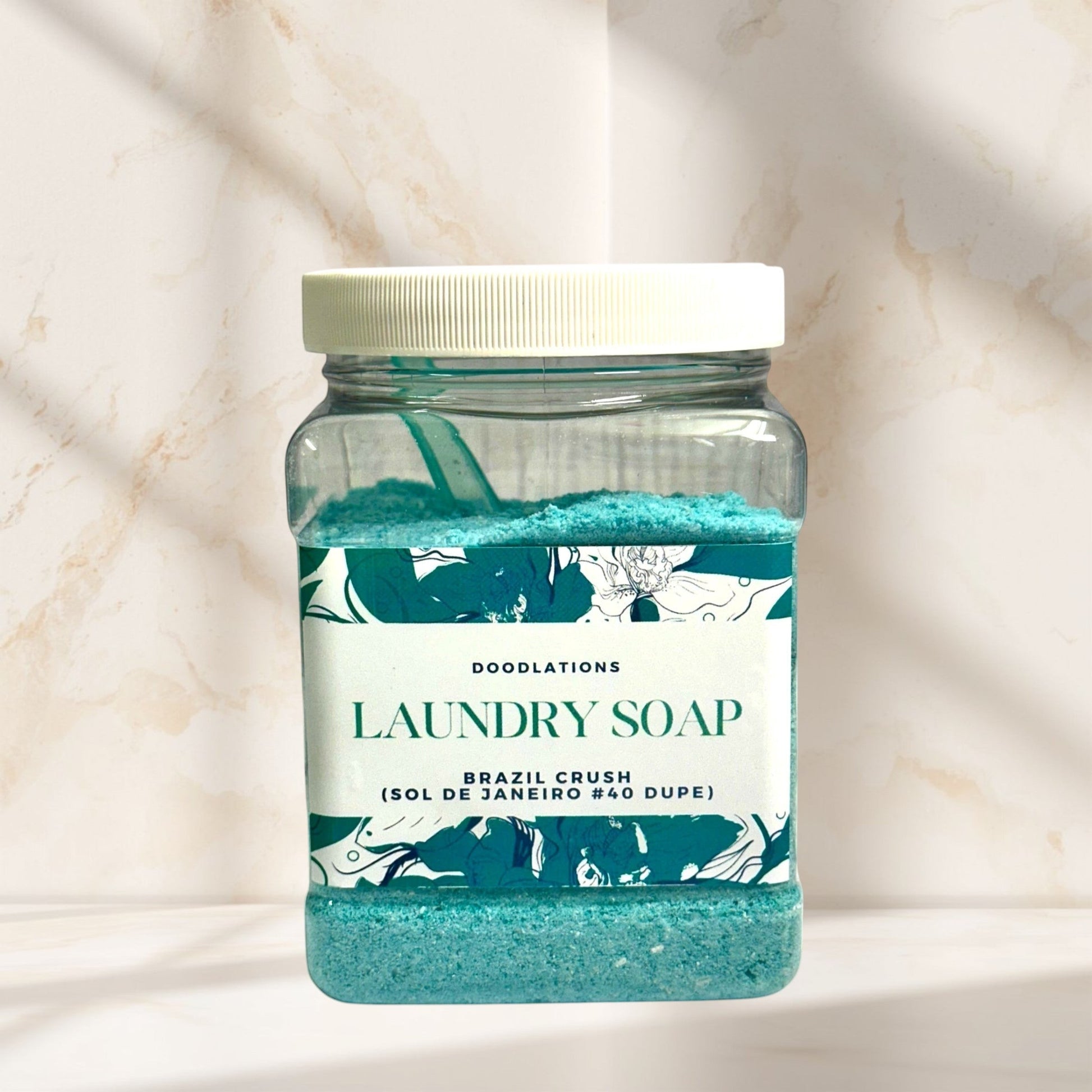 Doodlations Coffee Bar & Boutique Brazil Crush luxury laundry soap powder in a clear jar with a scoop.