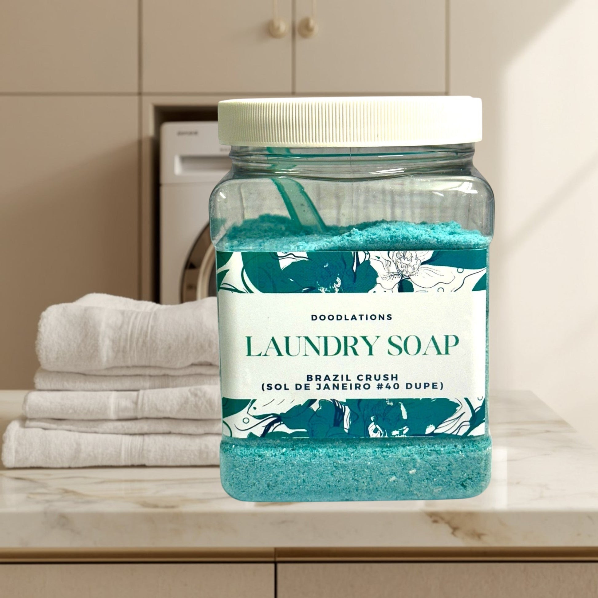 Doodlations Coffee Bar & Boutique Brazil Crush luxury laundry soap powder in a clear jar with a scoop. Teal powder with floral label.