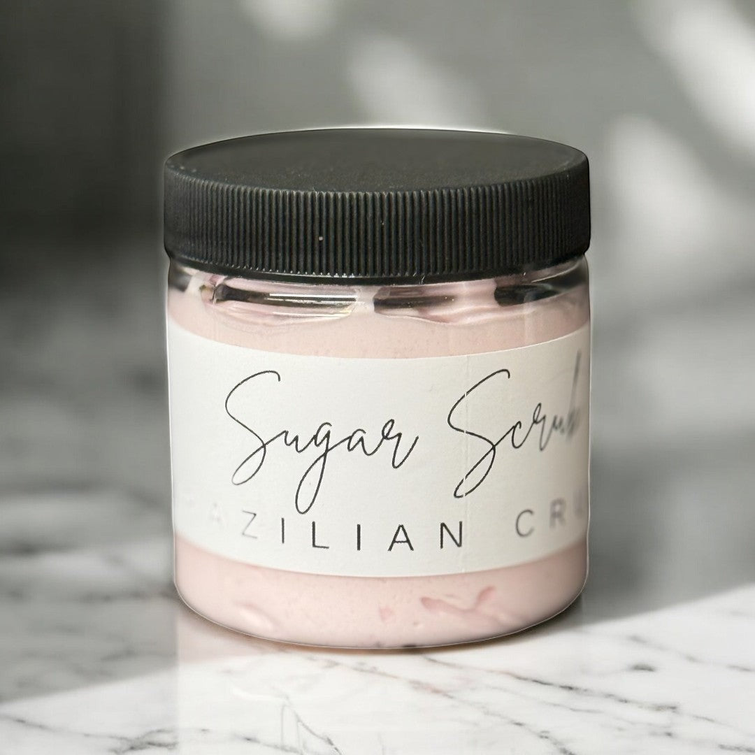 Doodlations Coffee Bar & Boutique Brazil Crush sugar scrub in a clear jar with a black lid. Pink scrub inside.