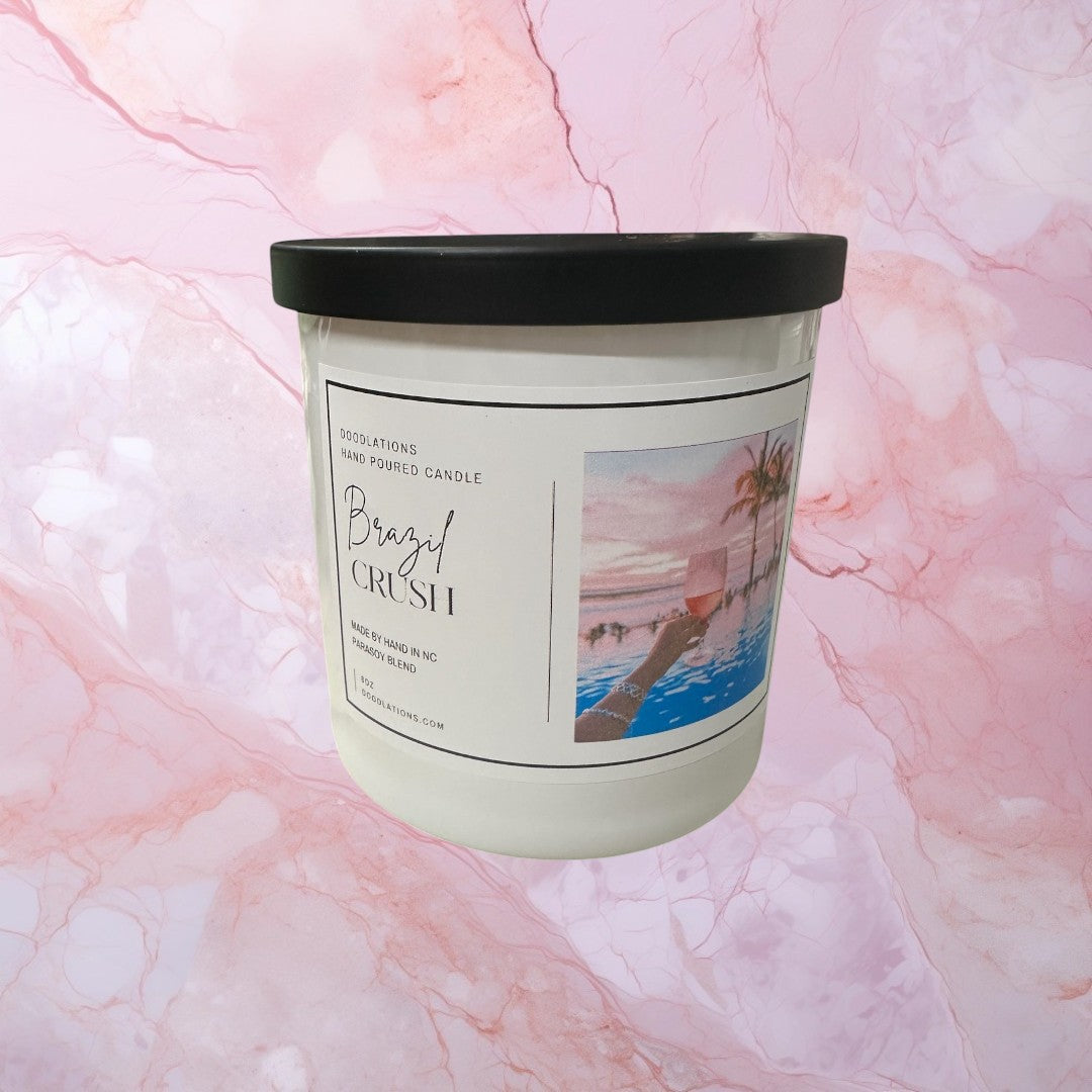 Doodlations Coffee Bar & Boutique Brazilian Crush hand-poured soy blend candle with tropical sunset label.