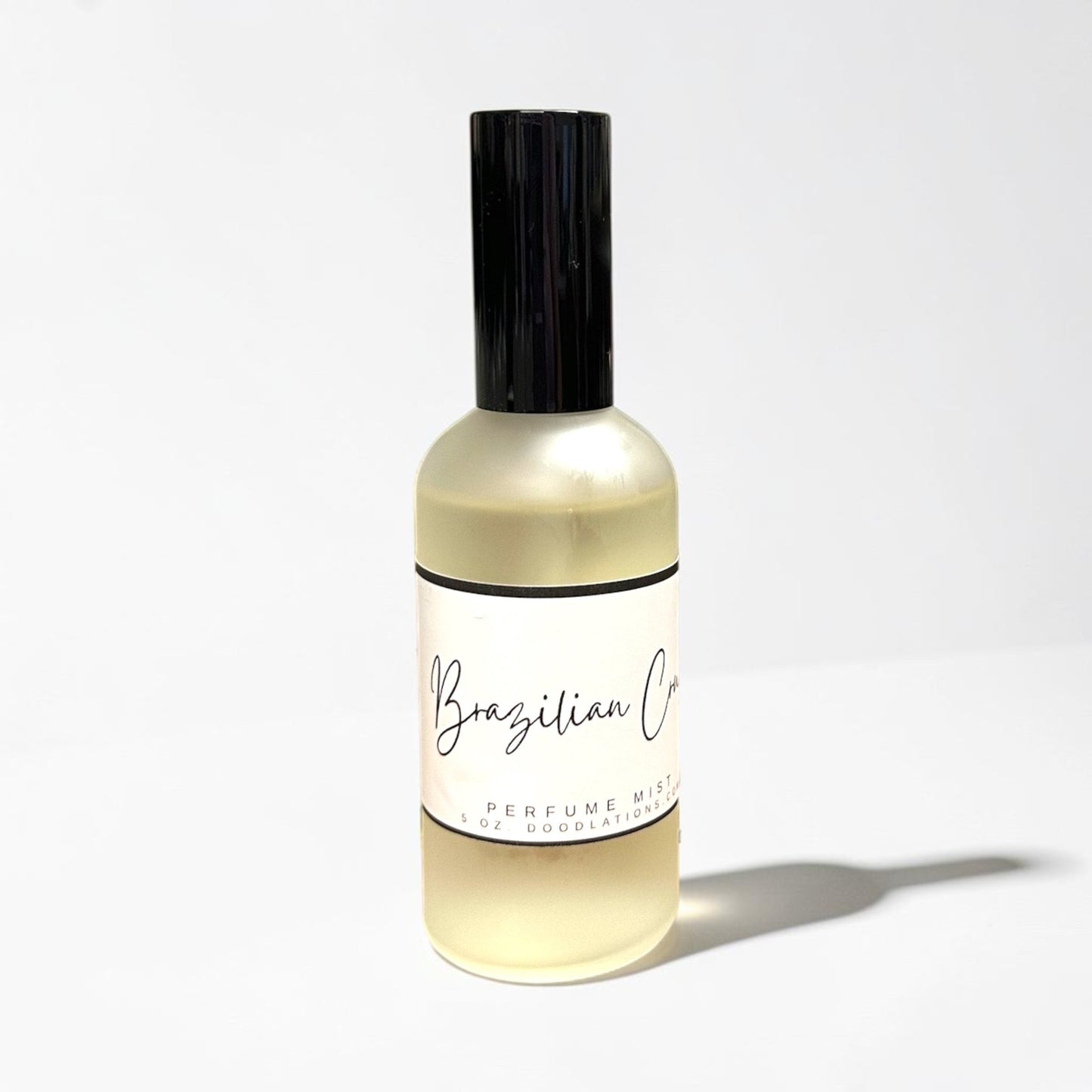 Doodlations Coffee Bar & Boutique Brazilian Crush fine mist perfume in a clear glass bottle with a black cap.