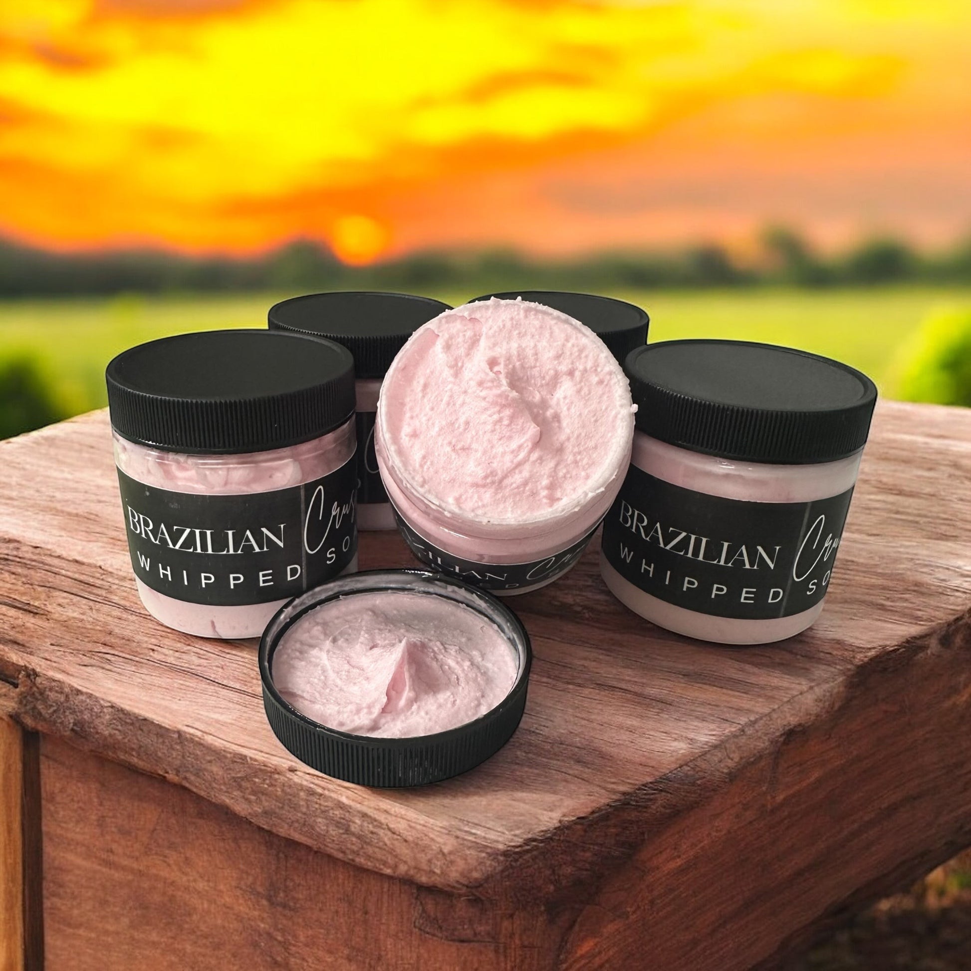 Doodlations Coffee Bar & Boutique Brazilian Crush whipped soap in pink, fluffy texture with black lids on wood.