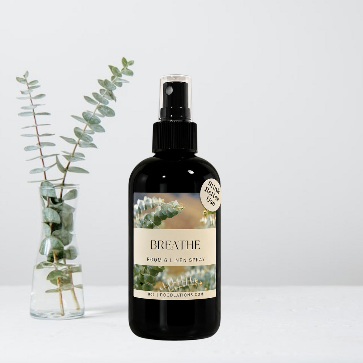 Doodlations Coffee Bar & Boutique Breathe room and linen spray in a black glass bottle with eucalyptus label design.