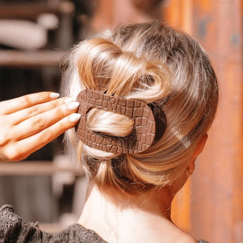 Doodlations Coffee Bar & Boutique brown crocodile print flat round hair clip worn in a blonde bun for comfortable hold
