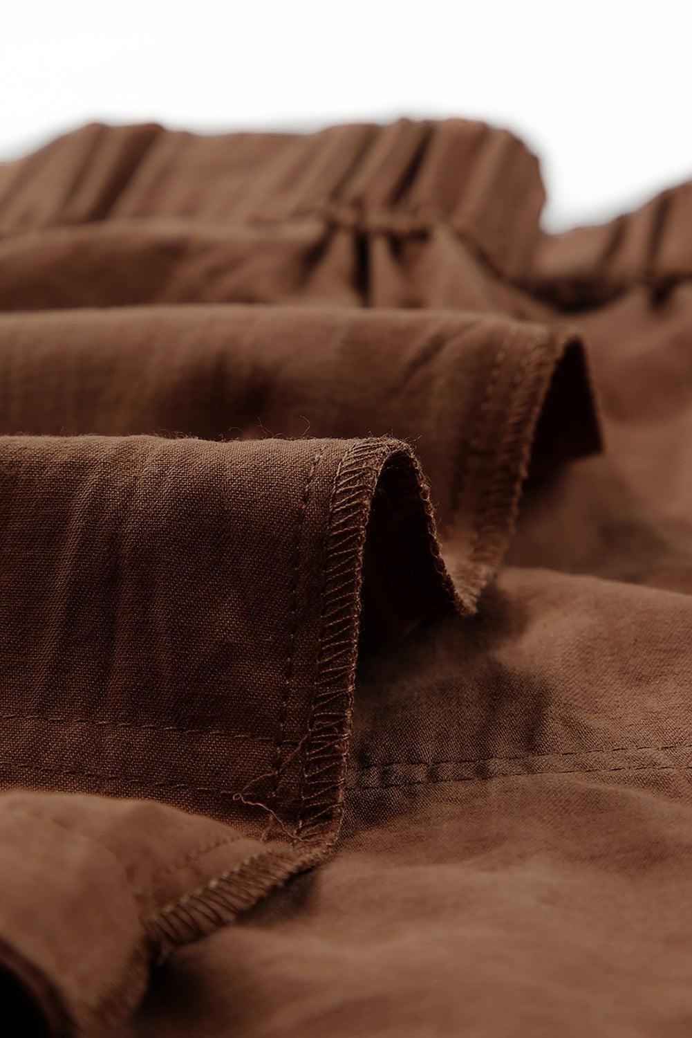 Doodlations Coffee Bar & Boutique brown linen-blend drawstring shorts with pockets and elastic waist.