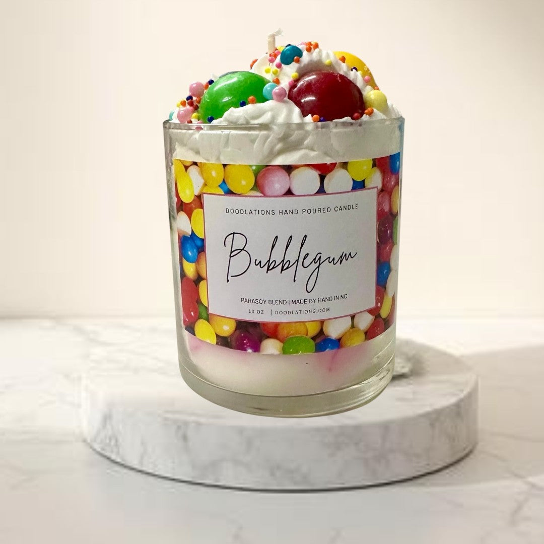 Doodlations Coffee Bar & Boutique Bubblegum candle with whipped wax topping, candy sprinkles, and a colorful gumball wrapper design.