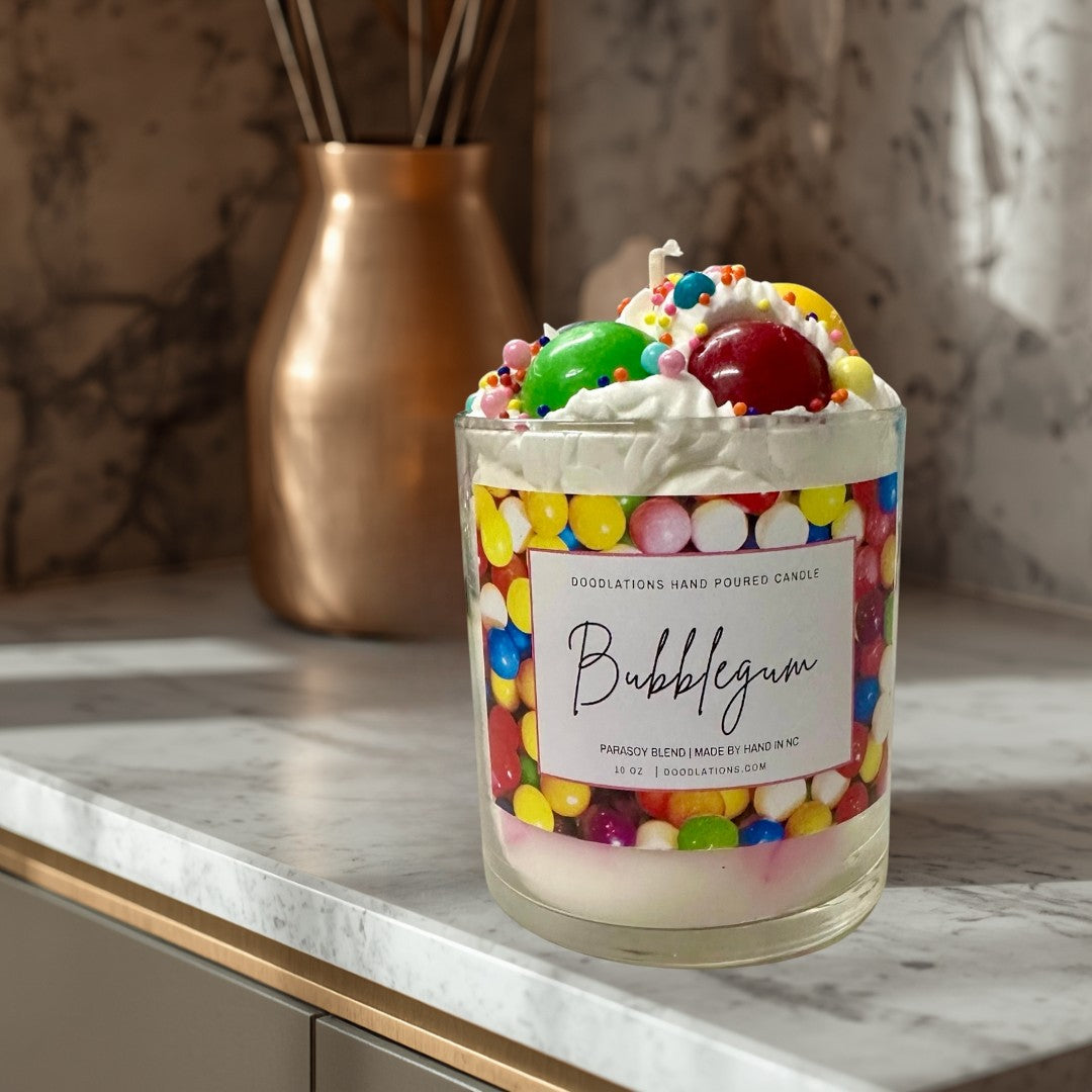 Doodlations Coffee Bar & Boutique Bubblegum candle with whipped wax topping, candy sprinkles, and a colorful gumball wrapper design.