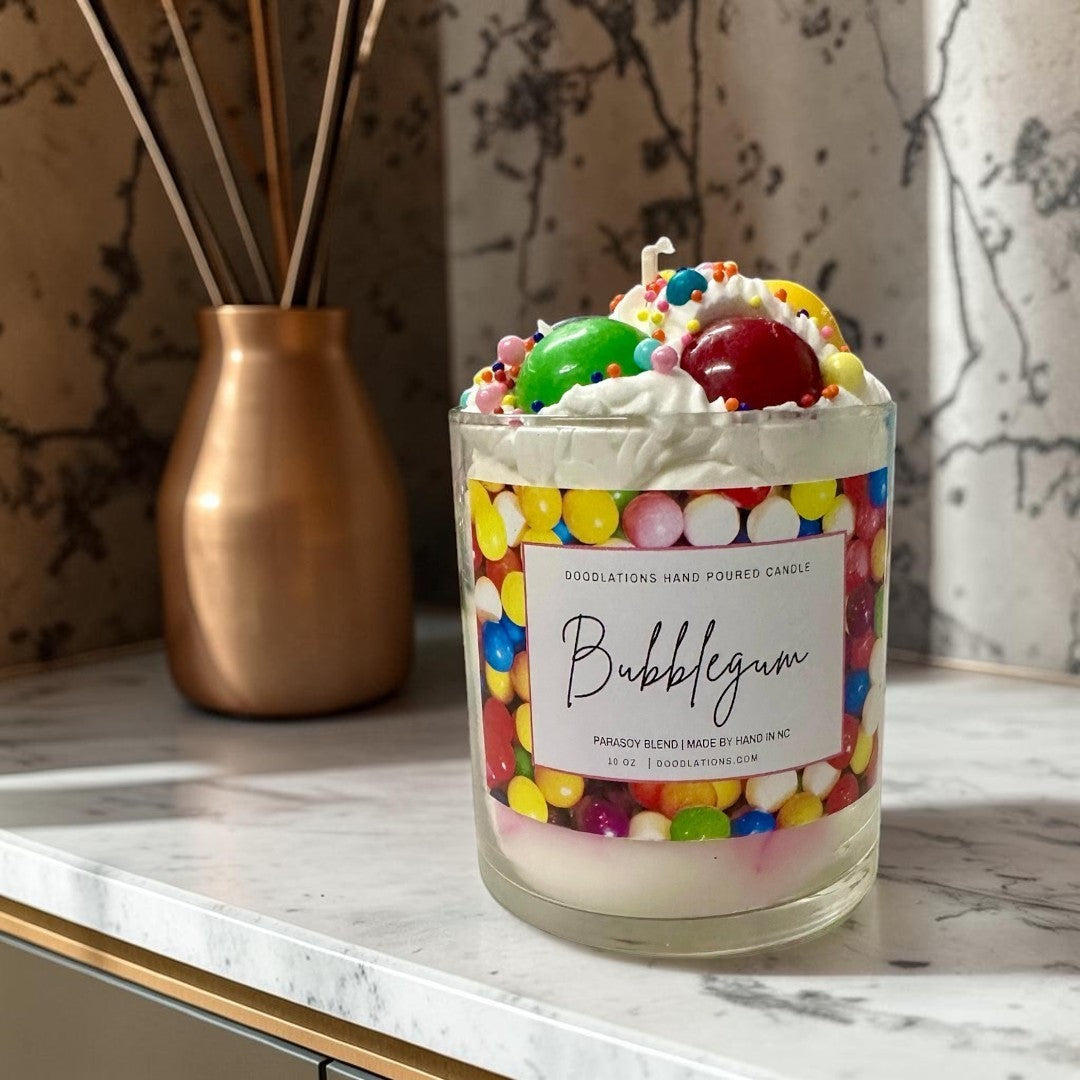 Doodlations Coffee Bar & Boutique Bubblegum candle with whipped wax topping, candy sprinkles, and a colorful gumball wrapper design.