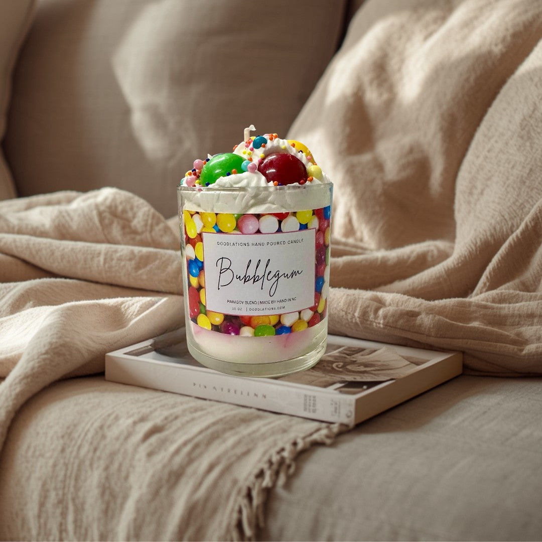 Doodlations Coffee Bar & Boutique Bubblegum candle with whipped wax topping, candy sprinkles, and a colorful gumball wrapper design.