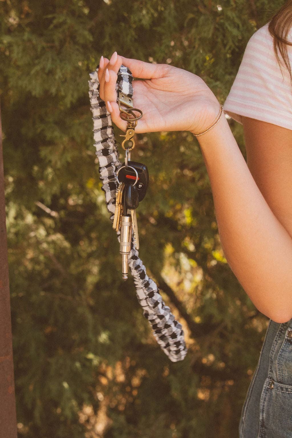 Doodlations Coffee Bar & Boutique black and white buffalo check fabric lanyard held in a hand with keys attached
