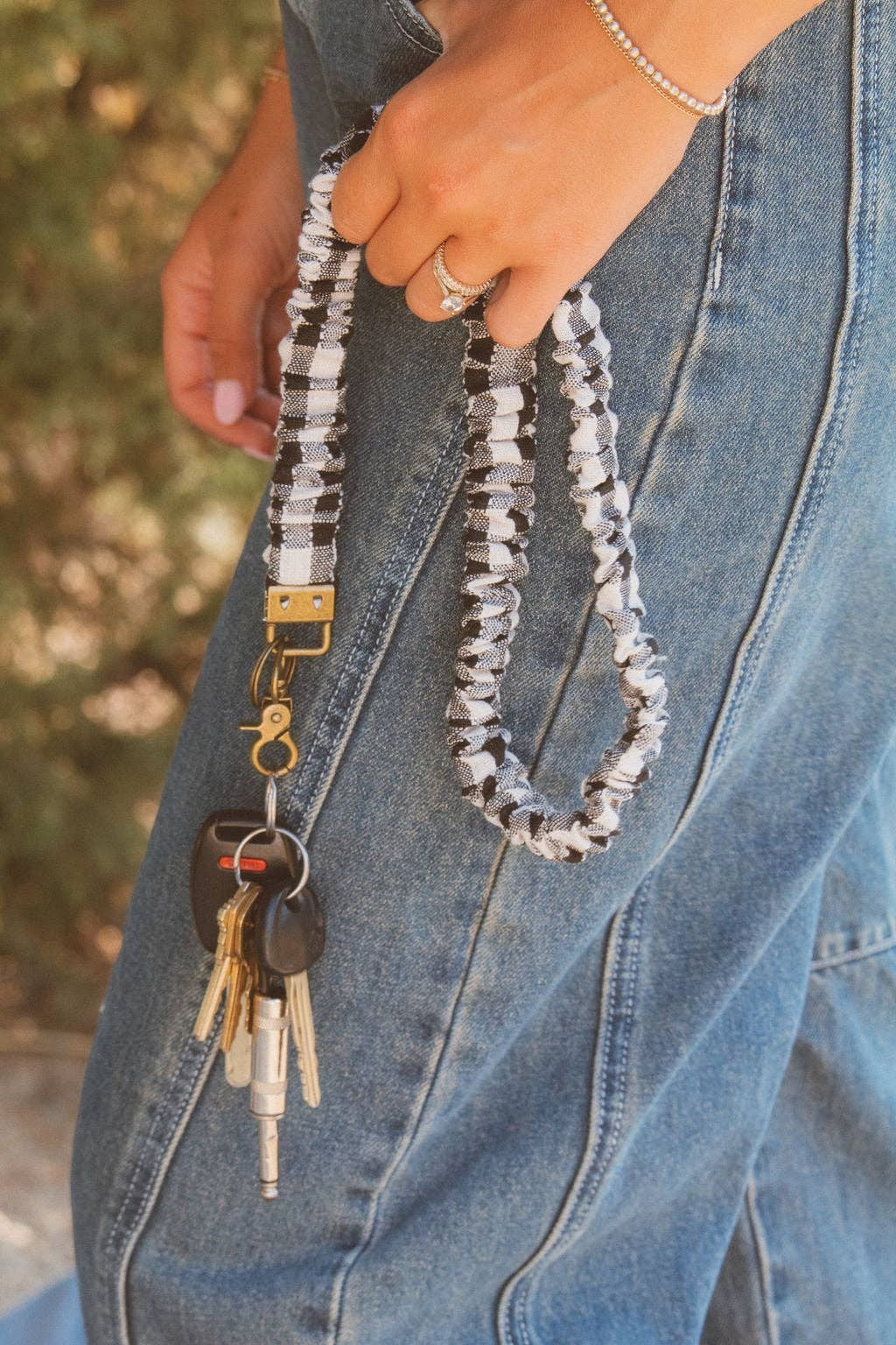 Doodlations Coffee Bar & Boutique black and white buffalo check fabric lanyard with gold hardware holding car keys