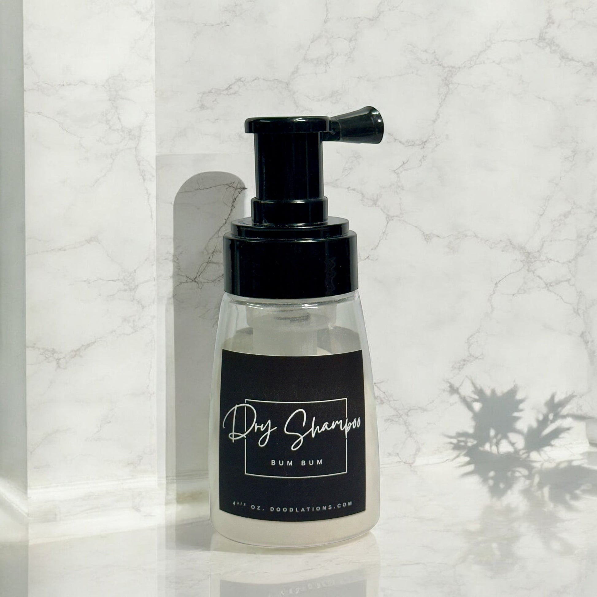 Doodlations Coffee Bar & Boutique Bum Bum dry powder shampoo in a clear pump bottle with a black label.