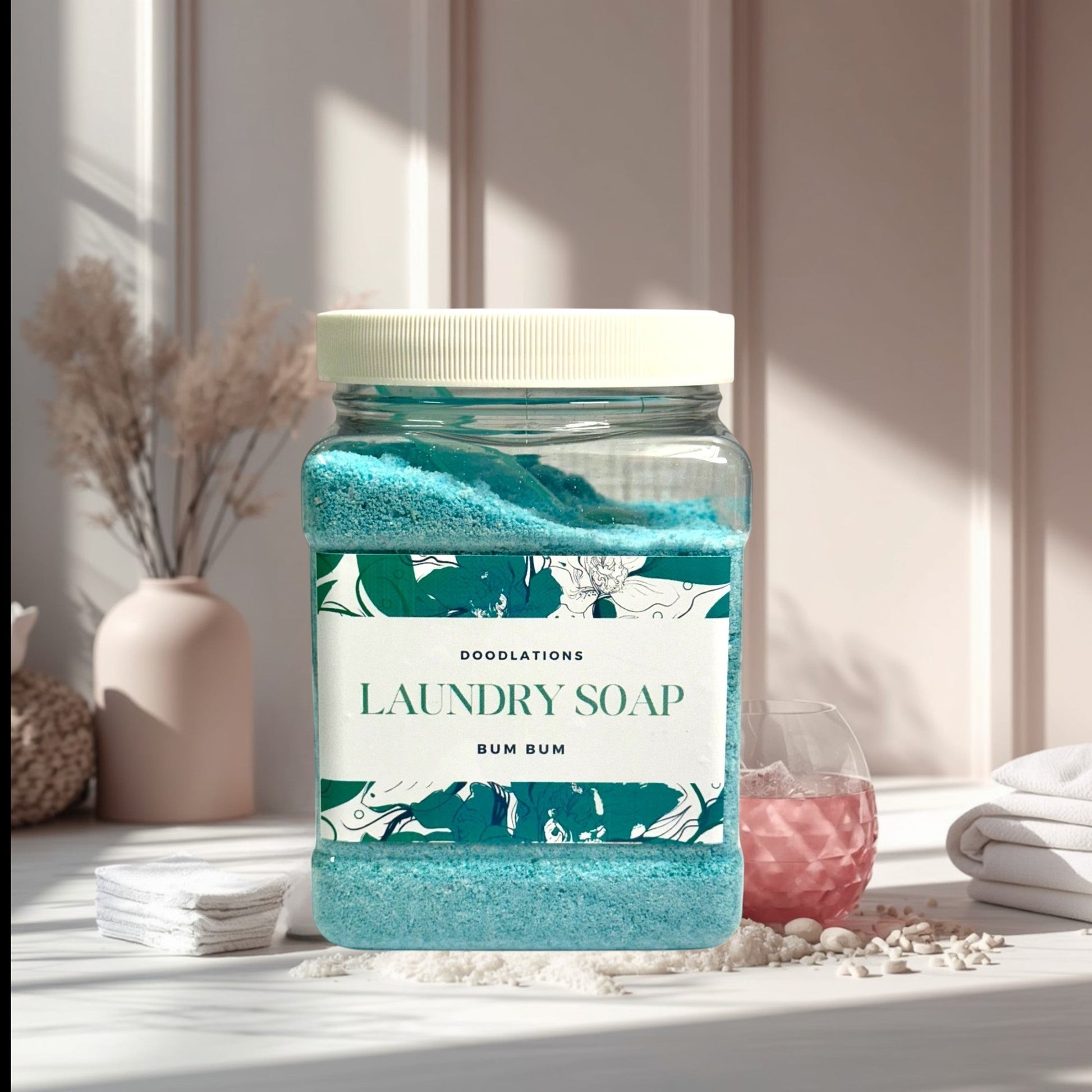 Doodlations Coffee Bar & Boutique Bum Bum luxury laundry soap powder in a clear jar with a white lid. The powder is bright turquoise.