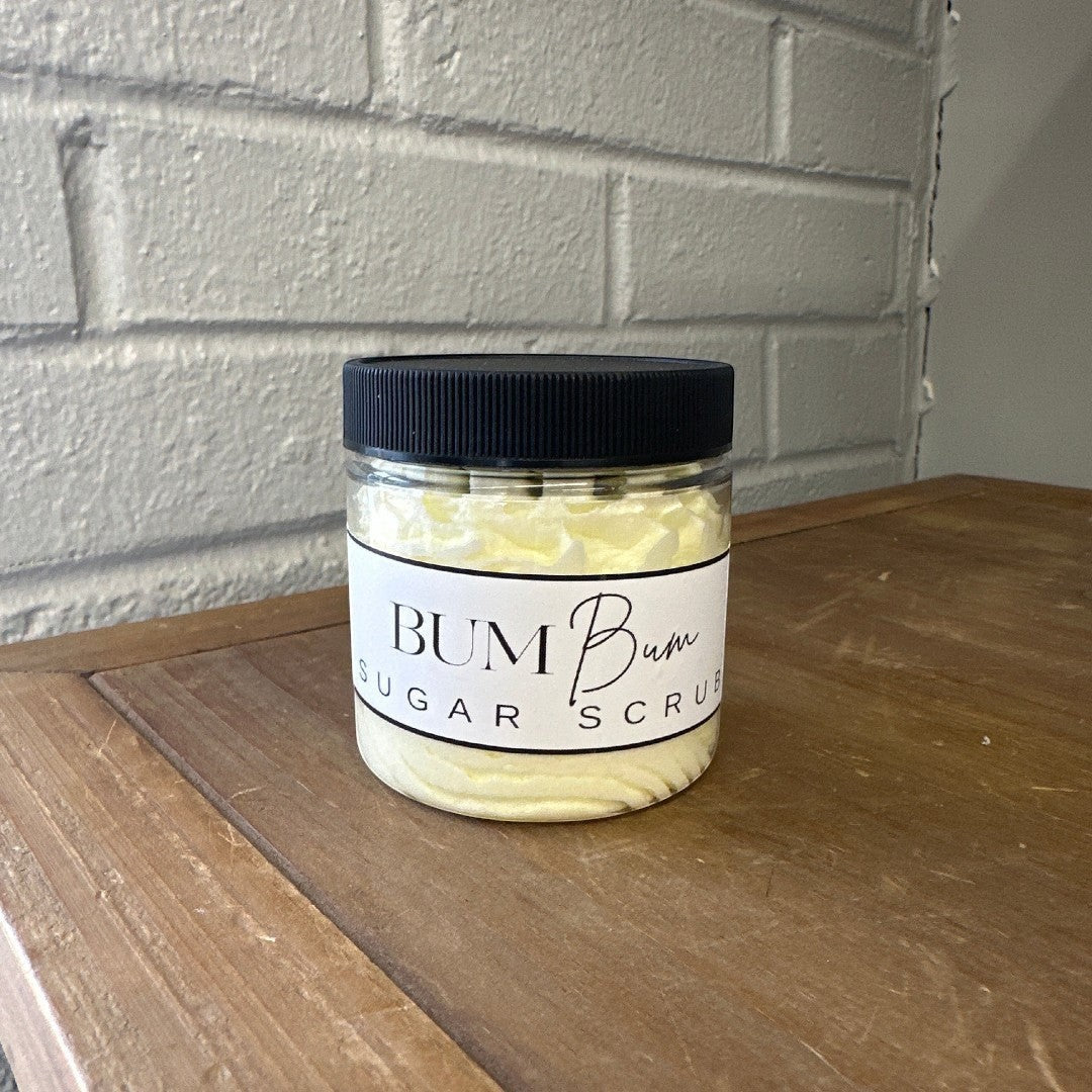 Doodlations Coffee Bar & Boutique Bum Bum Sugar Scrub in a clear jar with a black lid. Light yellow scrub with a white label.