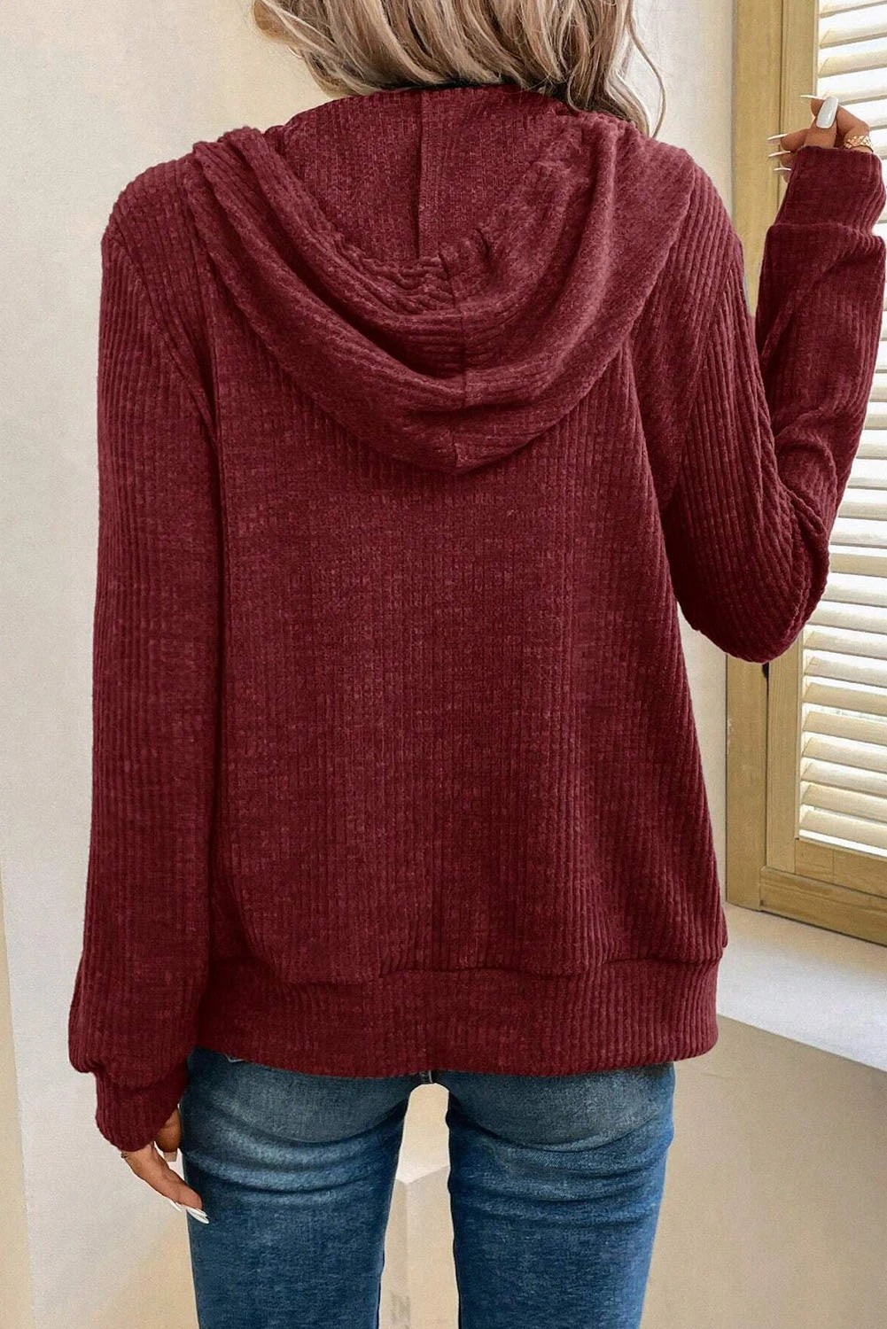 Back view of a Doodlations Coffee Bar & Boutique burgundy ribbed zip-up hoodie with a drawstring hood.