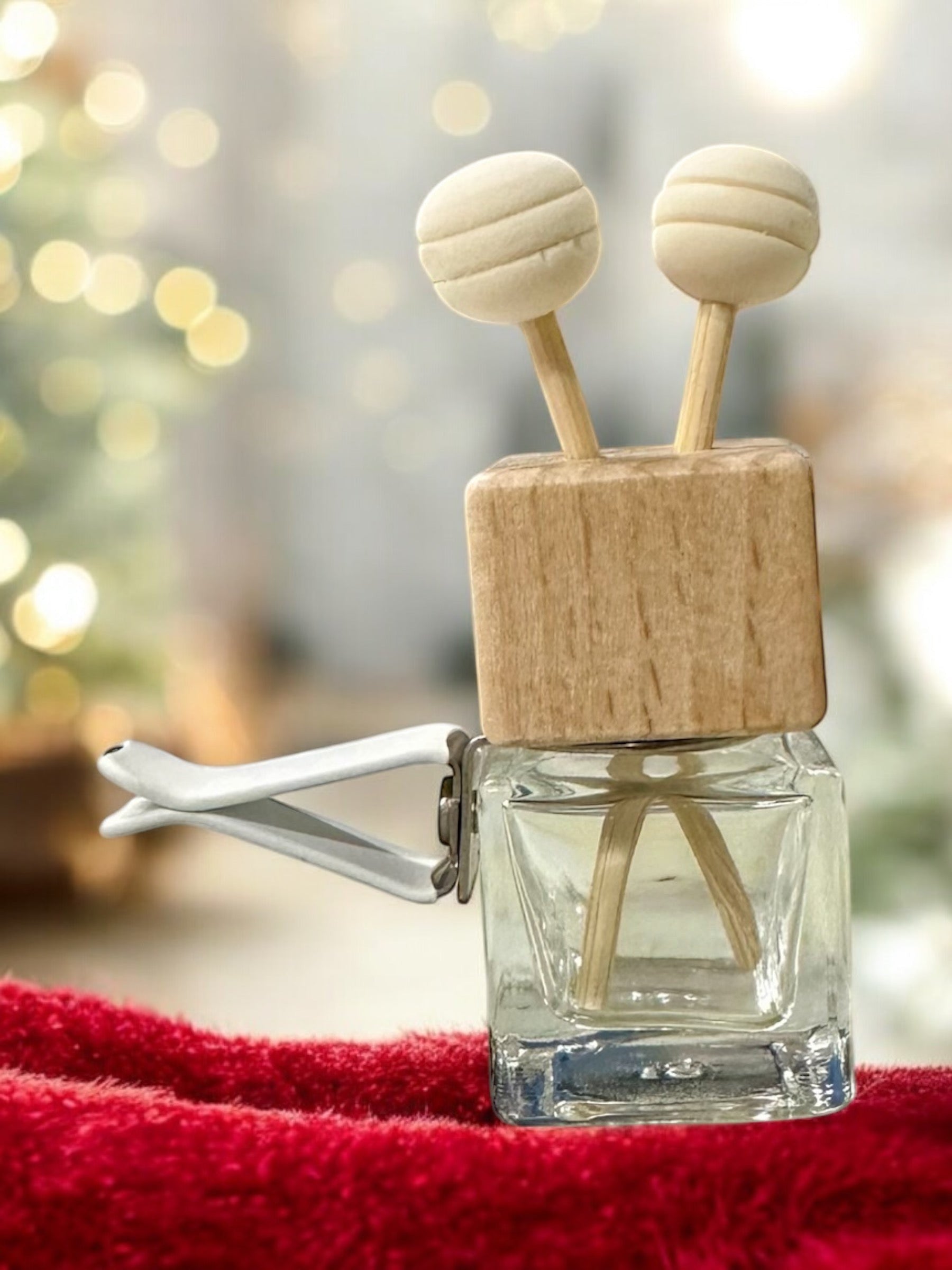 Doodlations Coffee Bar & Boutique car air freshener with a wooden block, glass bottle, and two round wooden diffusers.