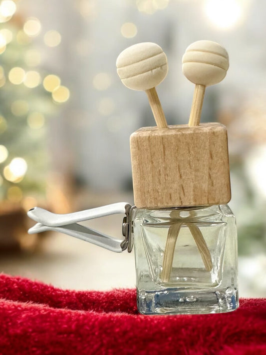 Doodlations Coffee Bar & Boutique car air freshener with a wooden block, glass bottle, and two round wooden diffusers.