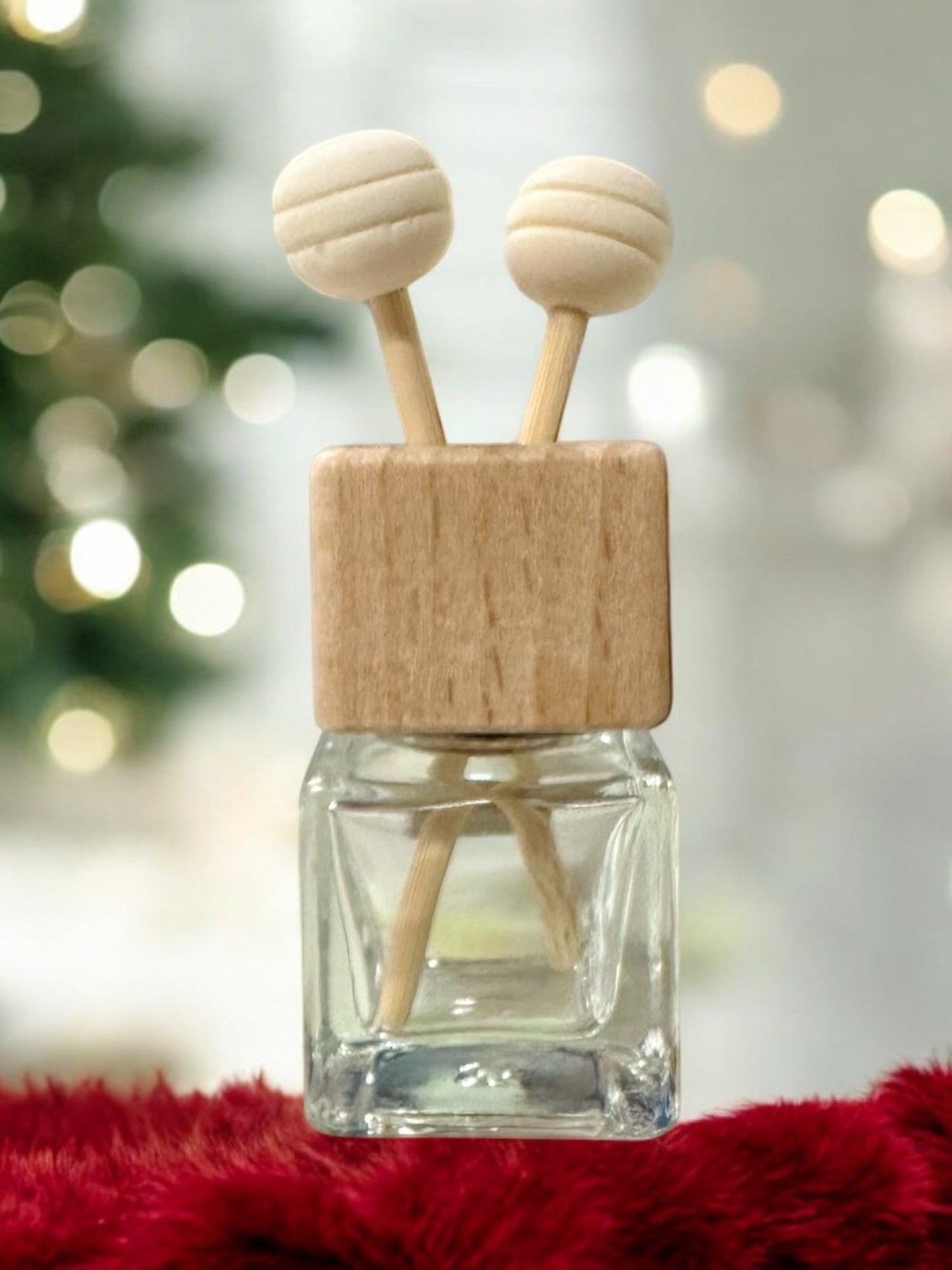 Doodlations Coffee Bar & Boutique car air freshener with a glass bottle, wooden cap, and two decorative wooden sticks.