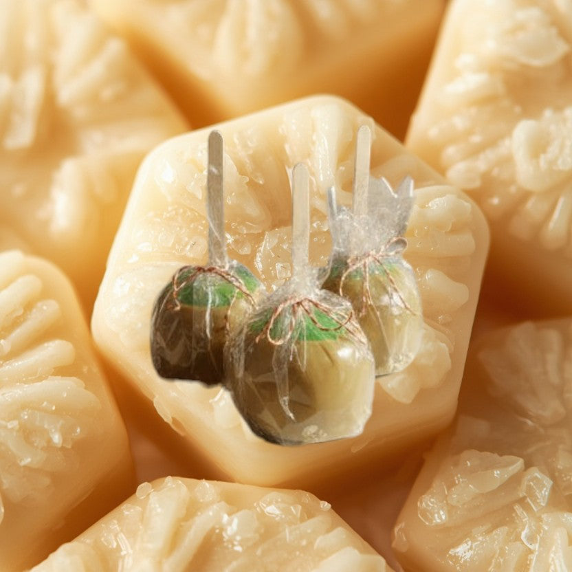 Doodlations Coffee Bar & Boutique Caramel Apple Wax Melt, a set of three caramel apples on sticks, individually wrapped in clear plastic.