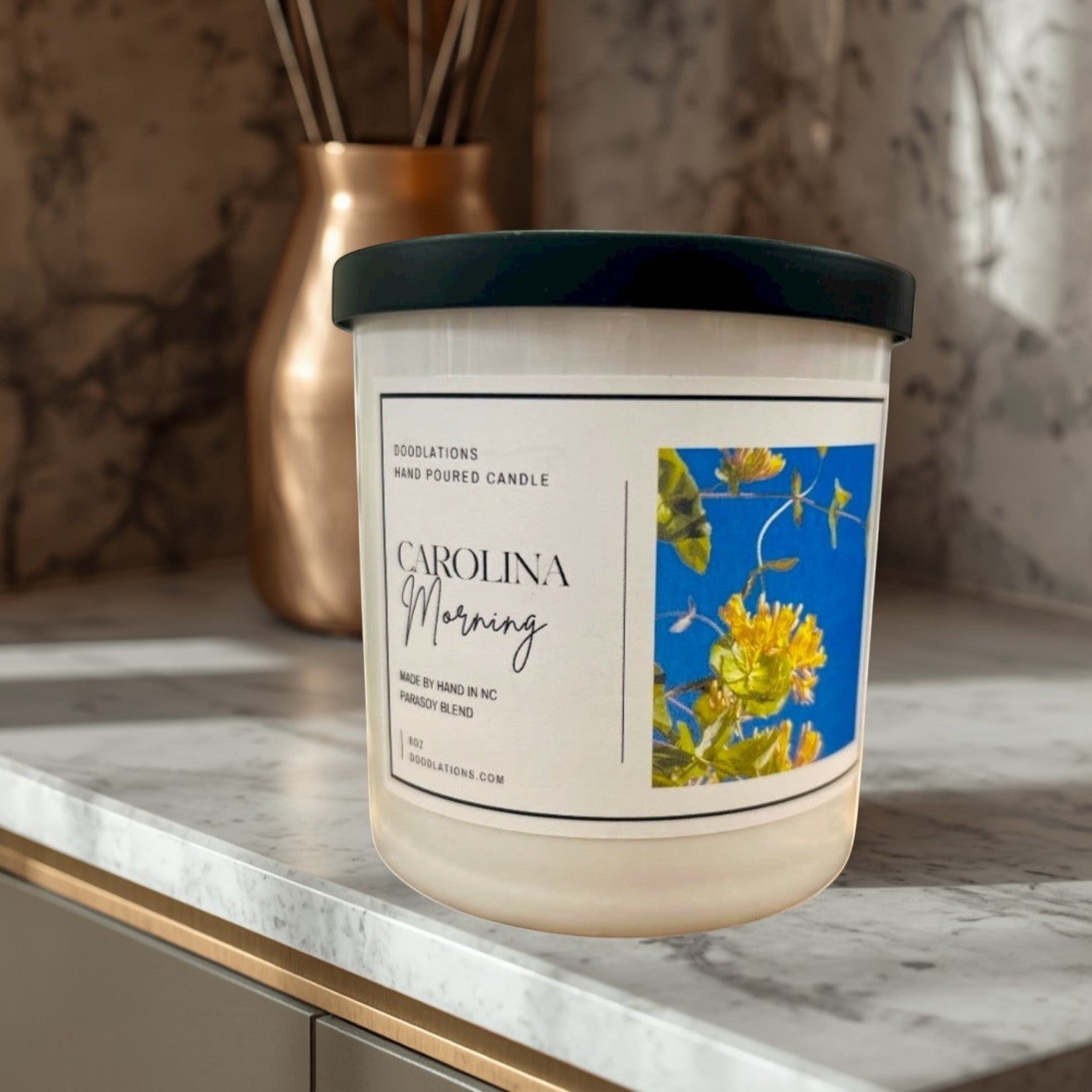Doodlations Coffee Bar & Boutique Carolina Morning hand-poured soy blend candle with floral label.