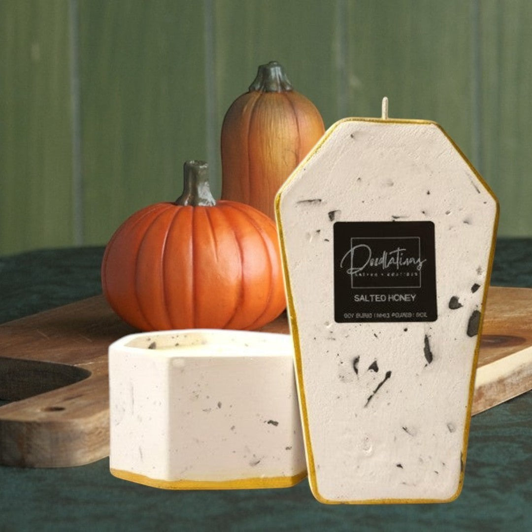 Doodlations Coffee Bar & Boutique casket-shaped concrete candle with gold trim, dual-wick, soy blend wax, salted honey scent.