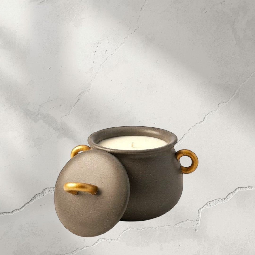 Doodlations Coffee Bar & Boutique cauldron concrete candle with gold handles and lid.