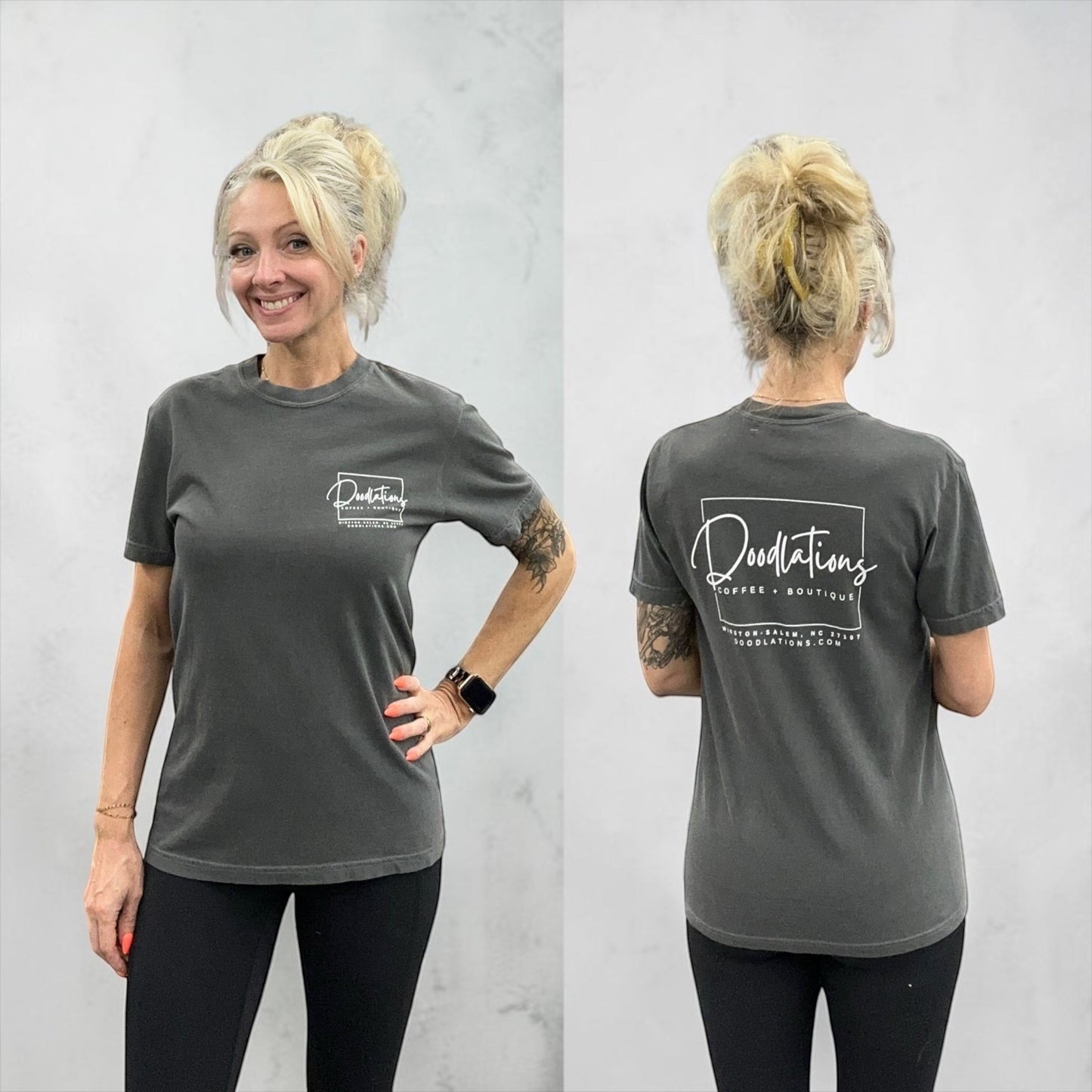 Doodlations Coffee Bar & Boutique charcoal grey cotton graphic tee with minimalist logo on front and back. Model is wearing black leggings.