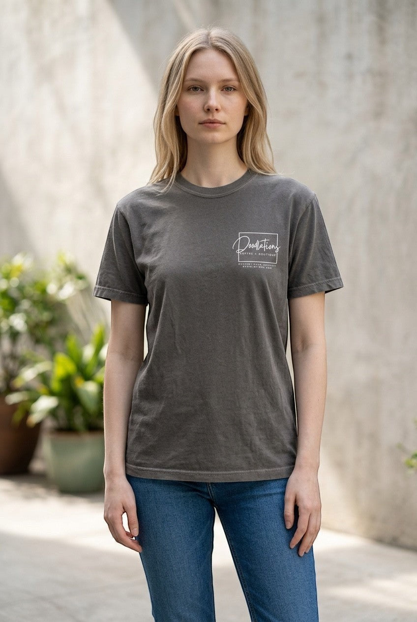 Woman wearing a charcoal grey Doodlations Coffee Bar & Boutique graphic tee with a white logo on the chest