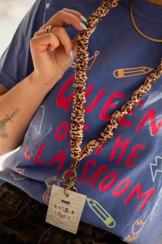 Doodlations Coffee Bar & Boutique cheetah print linen lanyard with gold hardware worn around the neck
