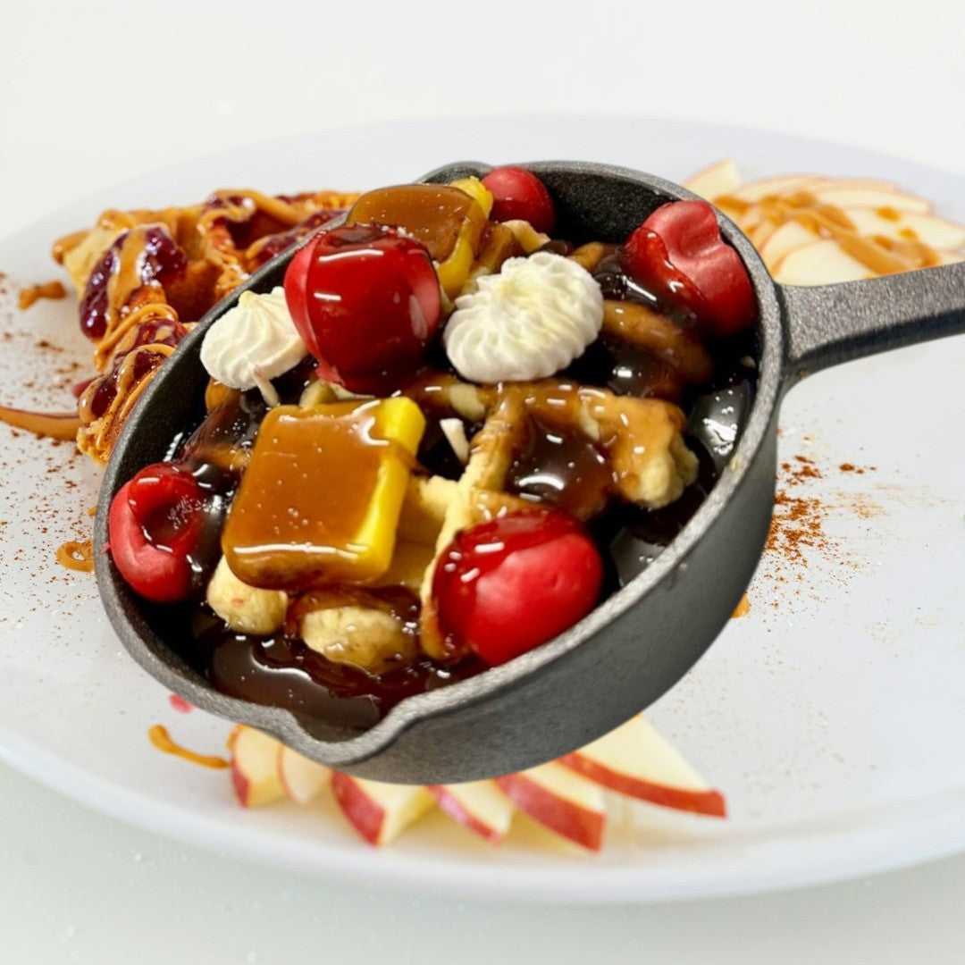 Doodlations Coffee Bar & Boutique Cherry Waffle Skillet Candle with chocolate syrup, cherries, caramel, and whipped cream.