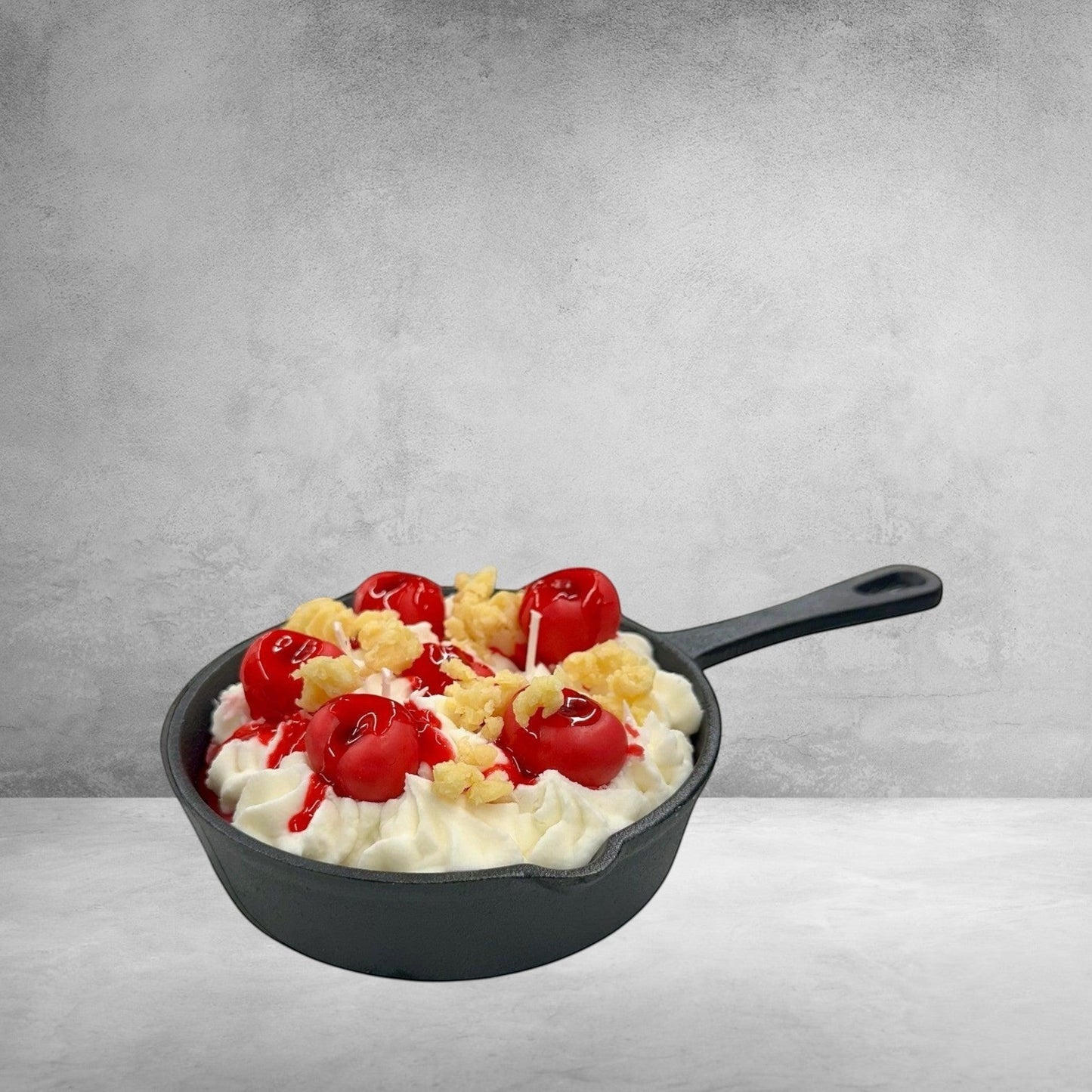 Doodlations Cherry Yum Yum candle in a mini iron skillet with wax cherries and whipped cream topping.