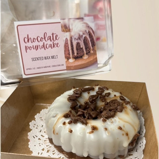 Doodlations Coffee Bar & Boutique Chocolate Pound Cake scented wax melt, shaped like a bundt cake with white icing and chocolate shavings.