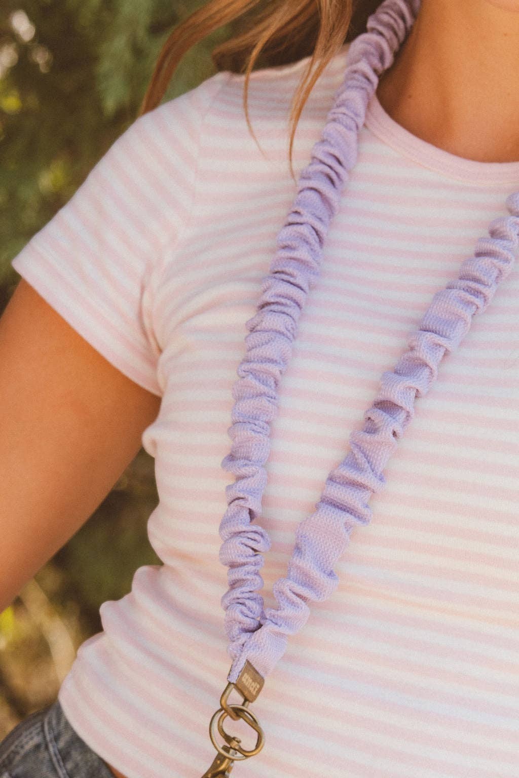 Doodlations Coffee Bar & Boutique chunky purple textured fabric lanyard worn around the neck with a gold clasp