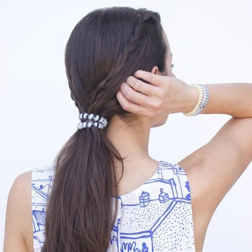 Doodlations Coffee Bar & Boutique Ciao Bella hair ties in yellow and blue worn in a ponytail and as a wrist bracelet